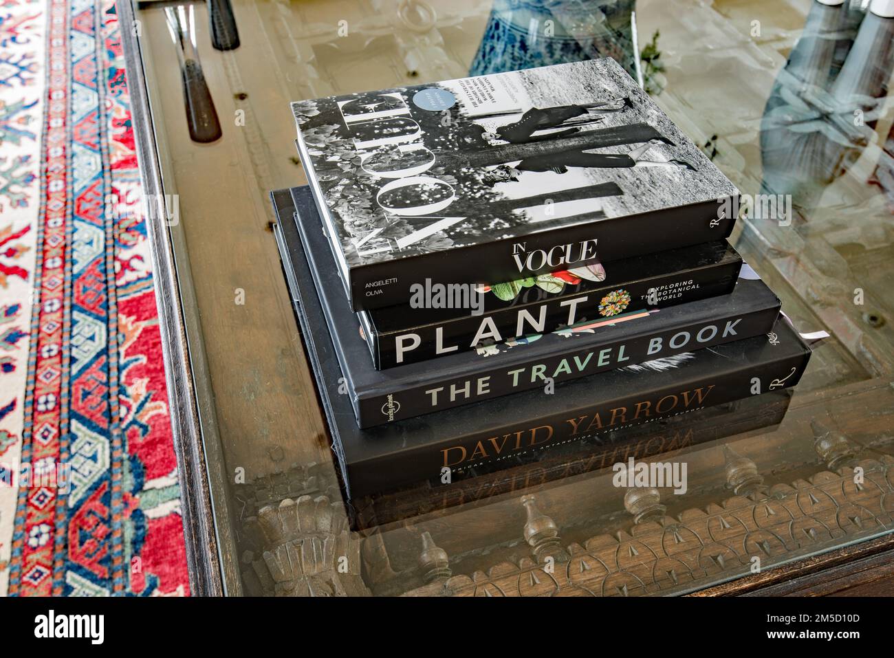 Libri eleganti e di tendenza in cima a un tavolo con tetto in vetro realizzato con un'antica porta di Dubai. Immagini stile rivista. Foto Stock
