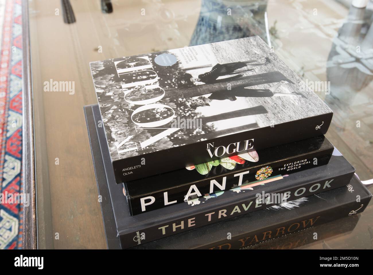 Libri eleganti e di tendenza in cima a un tavolo con tetto in vetro realizzato con un'antica porta di Dubai. Immagini stile rivista. Foto Stock