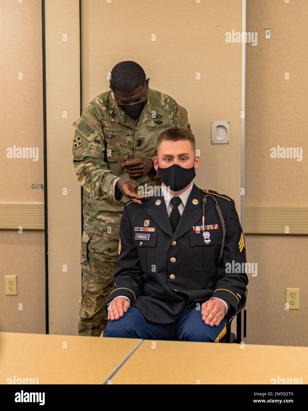 Jelani Edwards, capo senior arruolato, Division Artillery, 4th° divisione fanteria, conduce un'ispezione uniforme su Sgt. Jacob Fowler, un ufficiale chimico, biologico, radiologico e nucleare non commissionato assegnato a 2nd battaglione, 23rd reggimento fanteria, 1st Stryker Combat Team, 4th INF. Div., durante il Soldier of the Quarter Board, 3 marzo 2022, a Fort Carson, Colorado. Foto Stock