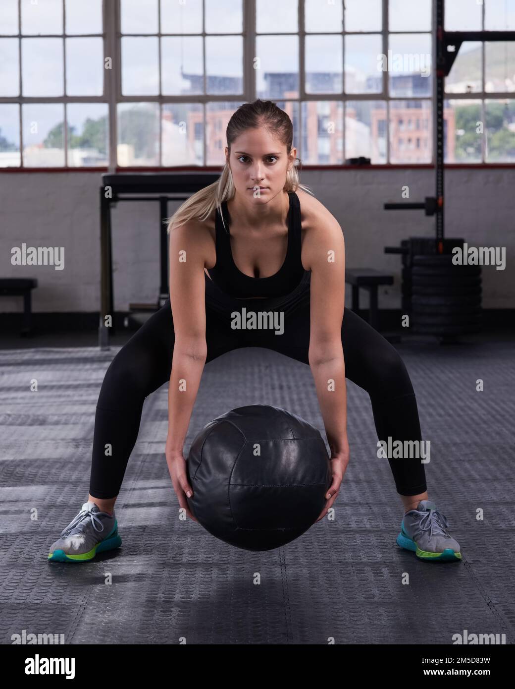 Piccole modifiche si aggiungono a grandi cambiamenti nel tempo. una giovane donna che usa una palla medica in una routine di esercizio fisico. Foto Stock