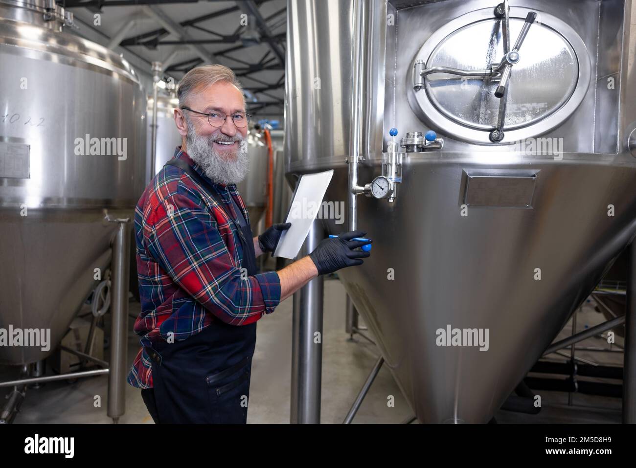 Birreria che controlla la pressione nei serbatoi con la birra Foto Stock