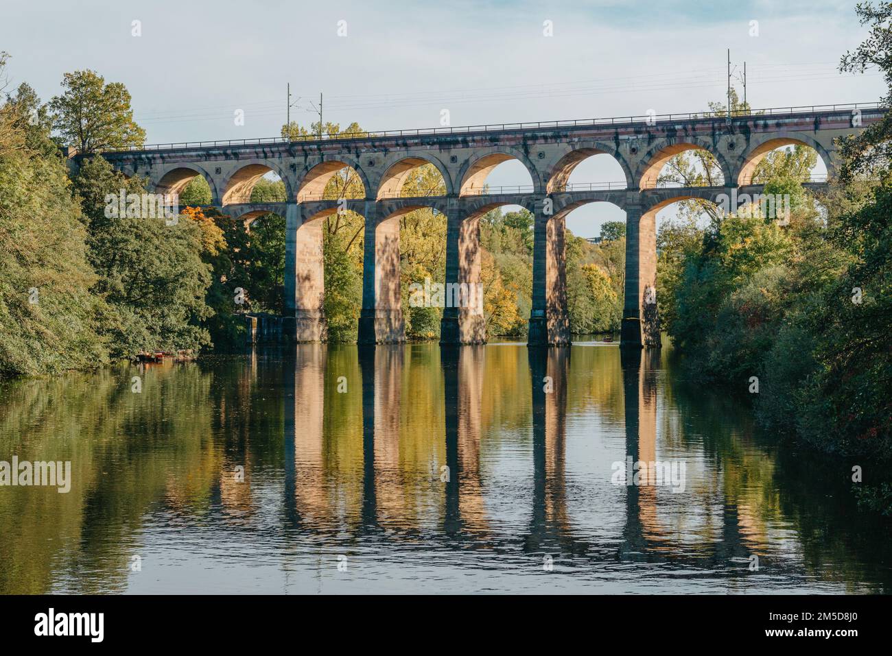 Ponte ferroviario con fiume a Bietigheim-Bissingen, Germania. Autunno. Viadotto ferroviario sul fiume Enz, costruito nel 1853 da Karl von Etzel su un soleggiato Foto Stock