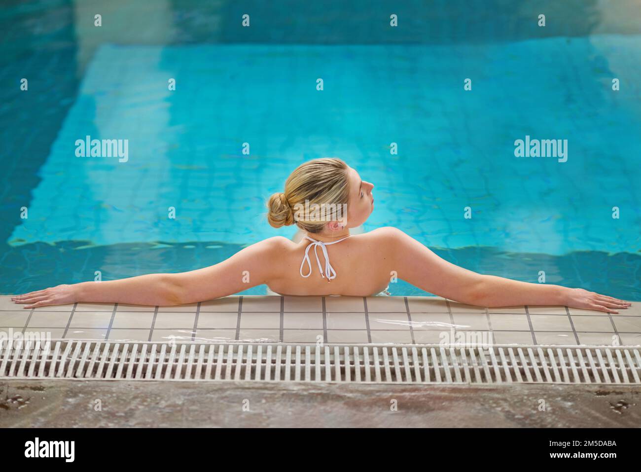 Acque calmanti per liberare la mente. Ripresa di una giovane donna che si rilassa in piscina presso un centro benessere. Foto Stock