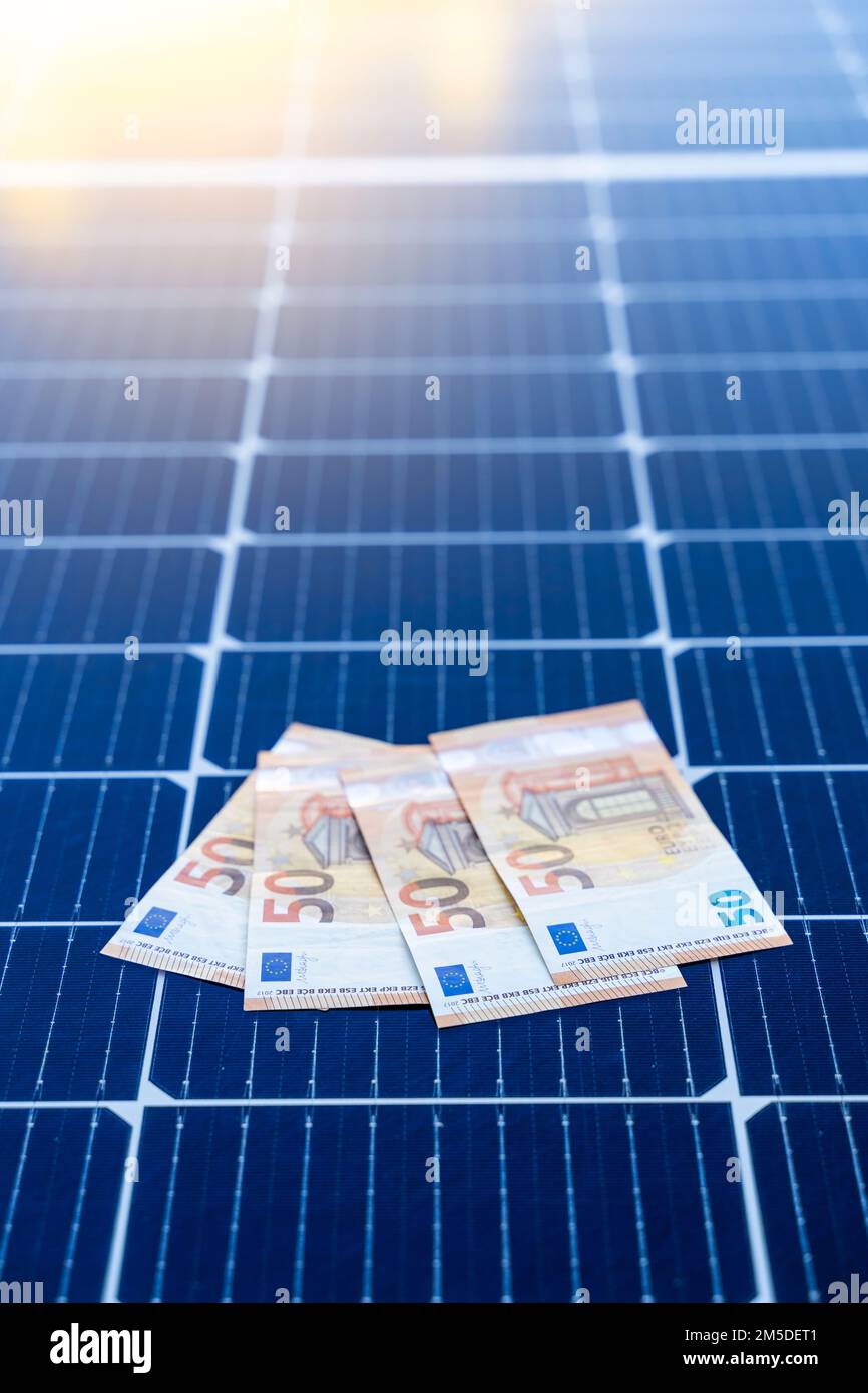 Concetto di risparmio energetico con pannelli solari e cinquanta euro di bollette Foto Stock