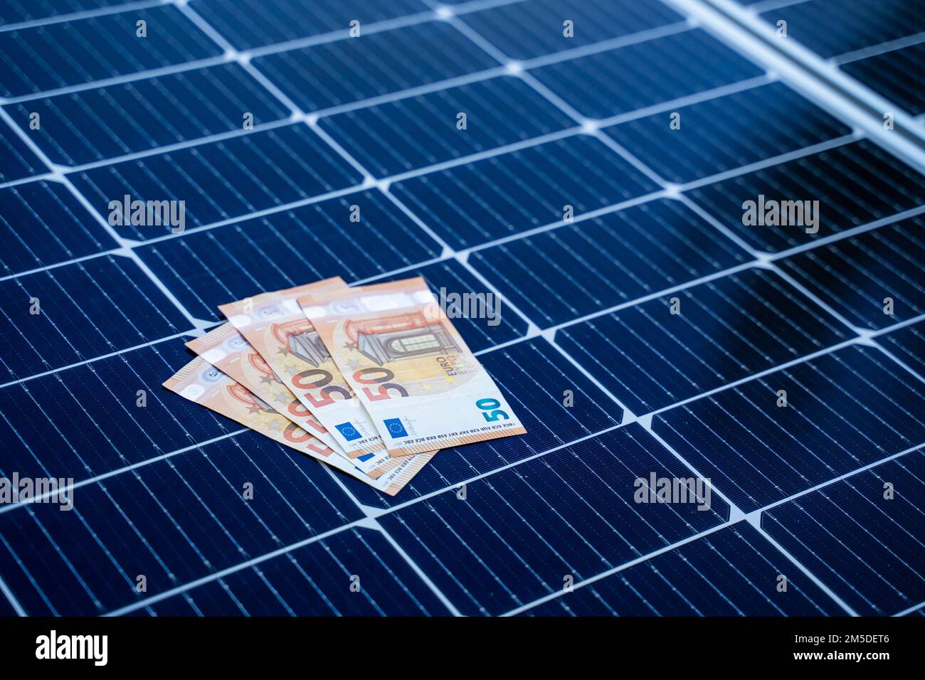 Concetto di risparmio energetico con pannelli solari e cinquanta euro di bollette Foto Stock