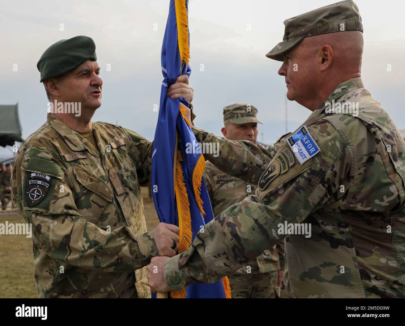 CAMPO BONDSTEEL, Kosovo – col. Brey Hopkins, destra, comandante, 86th squadra di combattimento della Brigata della Fanteria, Guardia Nazionale del Vermont, E il comando regionale della forza del Kosovo uscente - comandante est, passa la bandiera della NATO al maggiore ungherese, il generale Ferenc Kajári, comandante della KFOR, durante la cerimonia di trasferimento dell'autorità della KFOR RC-East a Camp Bondsteel, Kosovo, il 4 marzo 2022. L'IBCT del 86th ha ceduto la responsabilità della KFOR RC-East all'IBCT del 116th, Guardia Nazionale della Virginia, durante la cerimonia di trasferimento dell'autorità. Foto Stock