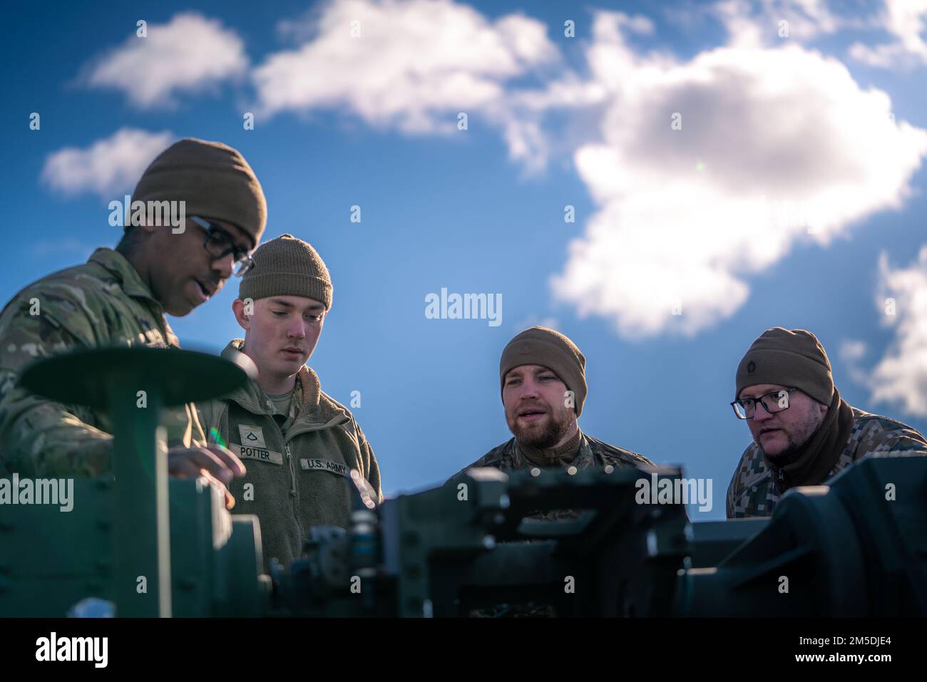 STATI UNITI Soldati dell'esercito SPC. Troynell Henderson e PFC. Jack Potter, assegnato al comando di difesa dell'aria e del missile dell'esercito 10th, spiegano le funzioni della torretta dello Stryker di difesa dell'aria a corto raggio di Manuever ai difensori dell'aria della difesa dell'aria di terra dell'aeronautica lettone durante l'attacco di Saber di esercitazione 22 ad Adazi, Lettonia il 4 marzo 2022. Le due unità hanno trascorso la giornata di formazione incrociata su attrezzature e procedure per migliorare ulteriormente l'interoperabilità della difesa aerea a corto raggio. L'esercizio si svolge fino a marzo con circa 13.000 partecipanti provenienti da 13 paesi ed è stato tenuto ogni 2 anni dal 2010. Foto Stock