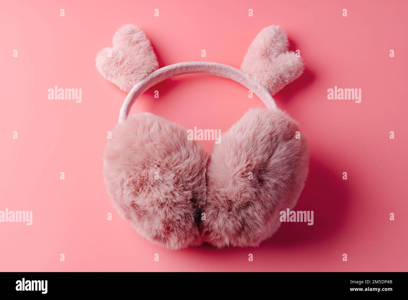 Soffici cuffie rosa calde su sfondo rosa Foto Stock