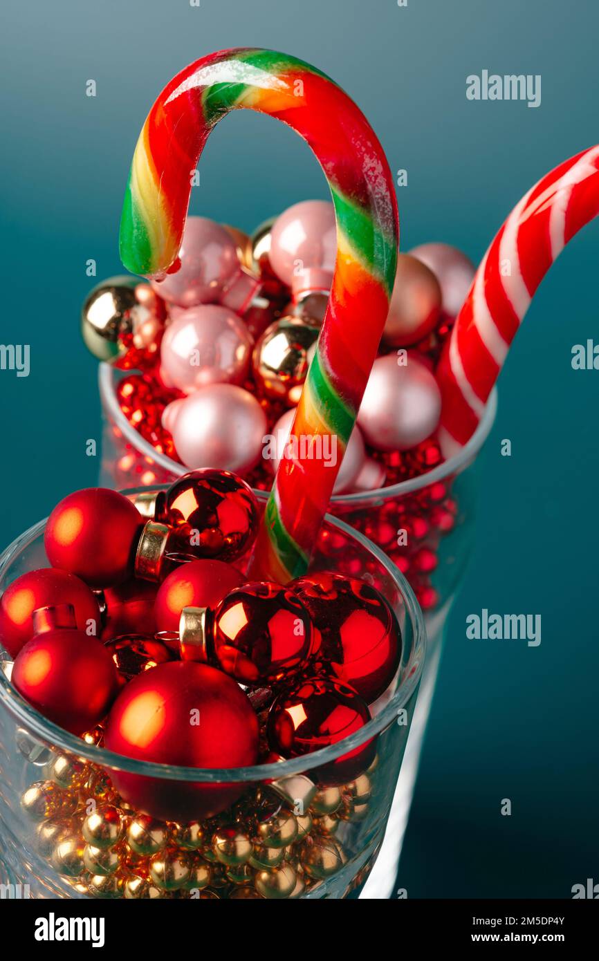 Bicchieri di vetro con decorazioni natalizie su sfondo verde scuro Foto Stock