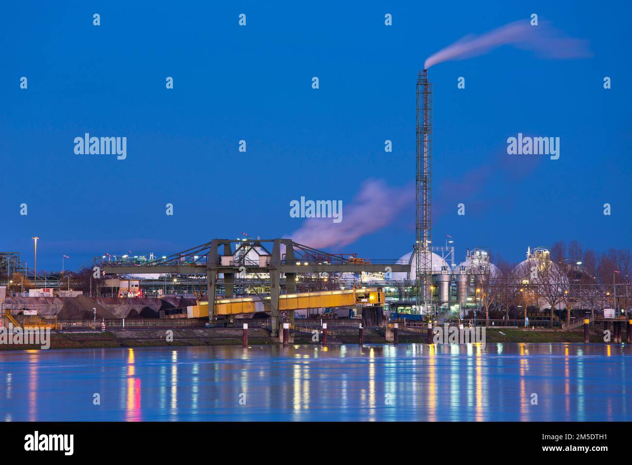 Parte di un impianto chimico presso un fiume in Germania la mattina presto Foto Stock