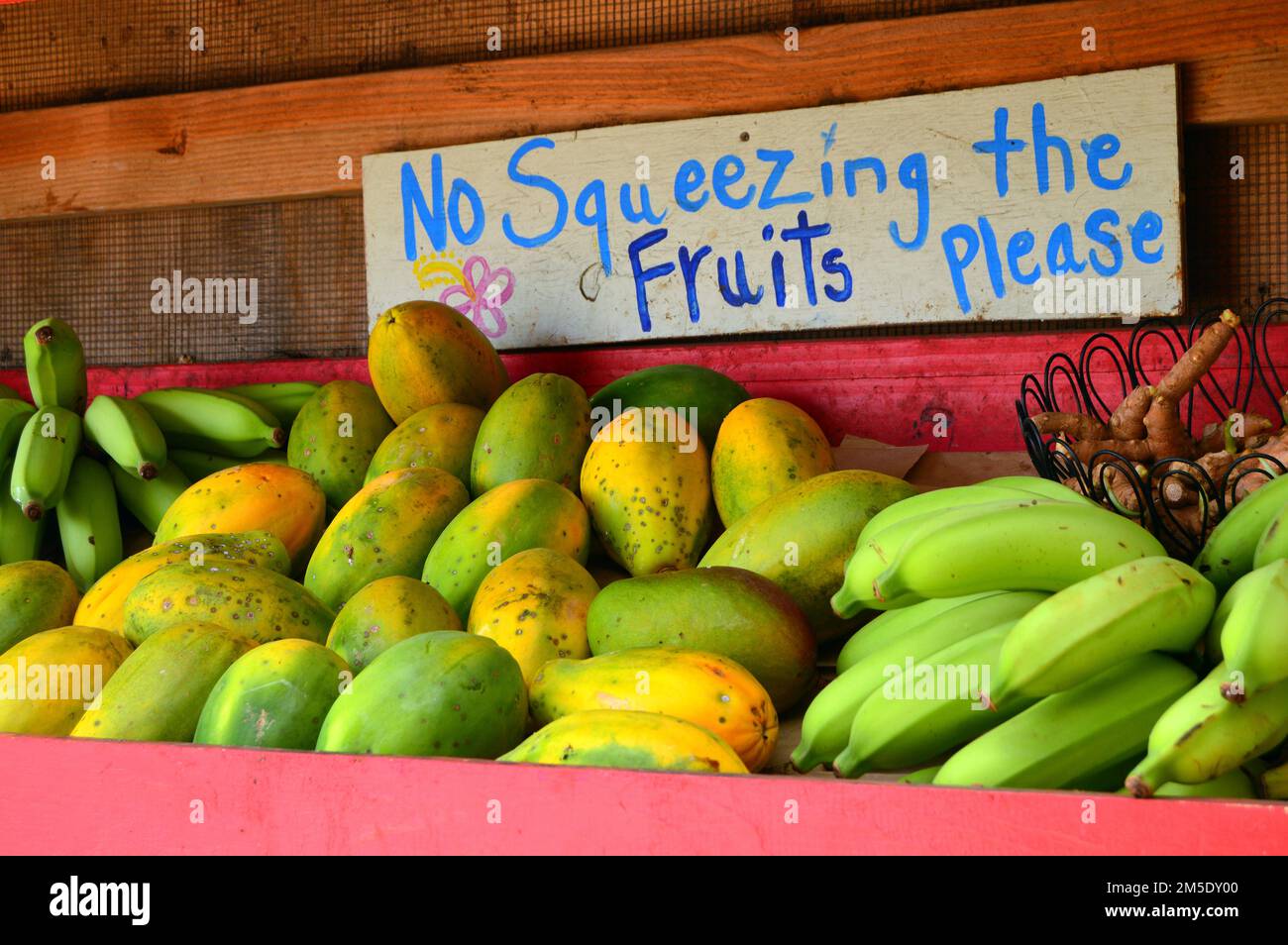 Un proprietario di piccola impresa fa una richiesta educata e divertente per quelli che acquistano la frutta fresca al carrello dell'alimento in Hawaii Foto Stock