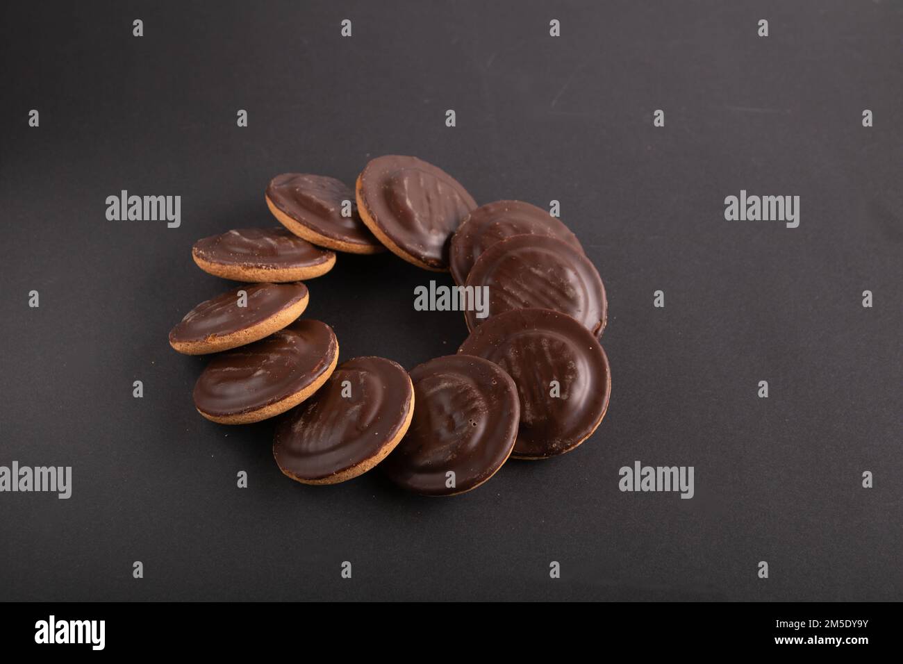 fotografa i biscotti ricoperti di cioccolato su sfondo nero Foto Stock