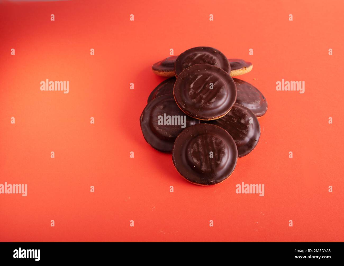 foto di un gruppo di biscotti ricoperti di cioccolato accanto a su sfondo viola su sfondo viola Foto Stock