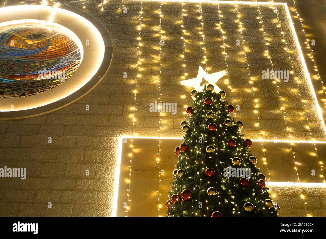 Le luci dei ghirlande sull'albero di Natale con le sfere rosse sono fuori fuoco. Foto Stock
