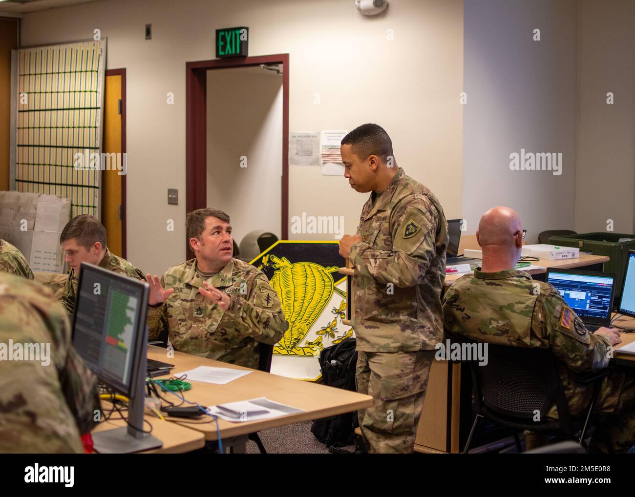 STATI UNITI Christopher Roberts, l'ufficiale di supporto per la sede centrale e la sede centrale (HHC), 60th comando della truppa (60th TC), la guardia nazionale del North Carolina, ascolta gli Stati Uniti Anthony Berge, l'ufficiale non commissionato delle operazioni senior per HHC, 60th TC, spiega uno scenario nozionale recentemente ricevuto durante l'esercizio Arctic Eagle-Patriot 2022 (AEP22) presso la sede della forza congiunta della Guardia Nazionale dell'Alaska presso la base militare Elmendorf-Richardson 5 marzo 2022. L'esercizio AEP22 aumenta la capacità della Guardia Nazionale di operare in ambienti austeri e con climi freddi acro Foto Stock