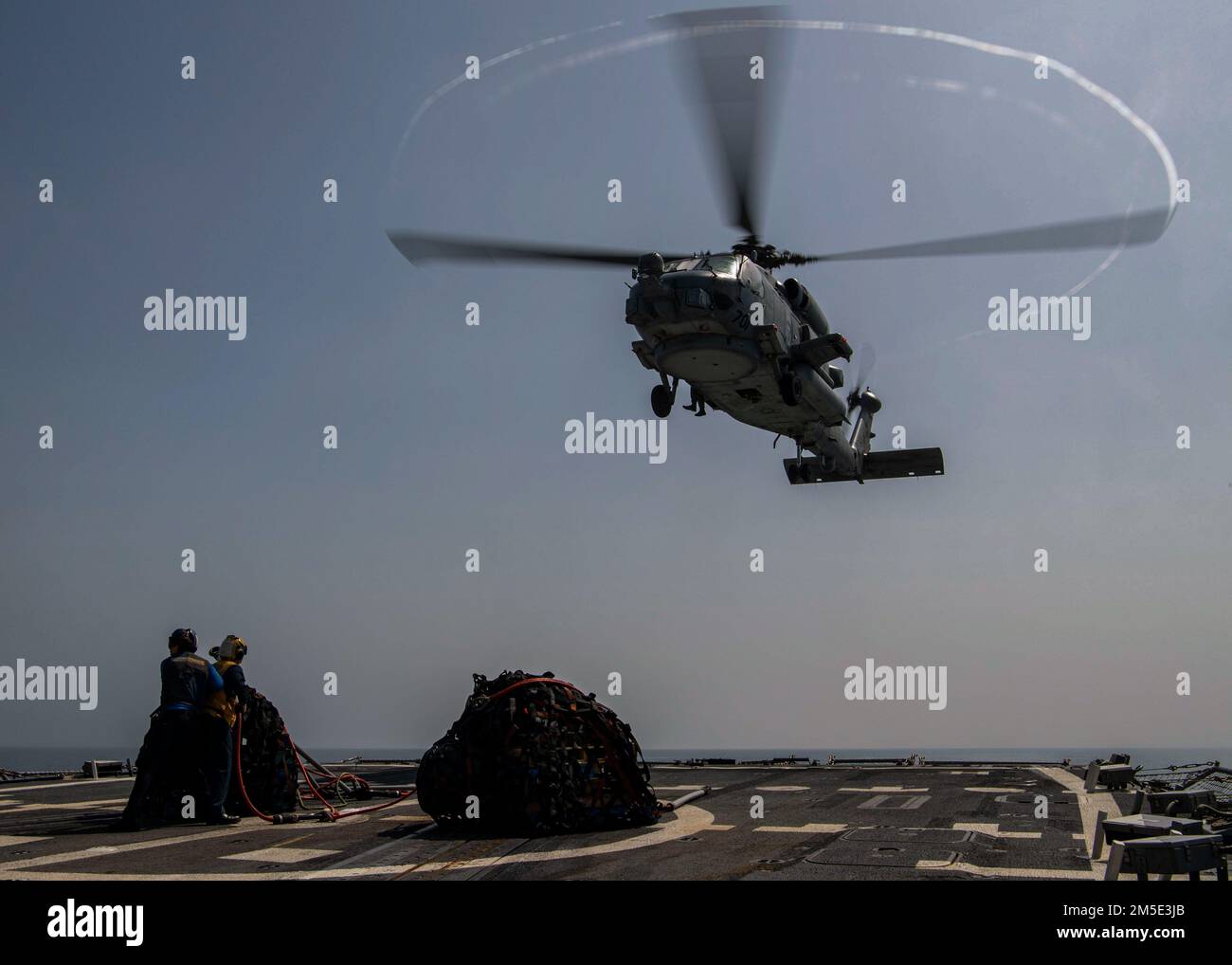 GOLFO D'OMAN (6 marzo 2022) un elicottero MH-60R Sea Hawk, attaccato ai "Raptors" di Helicopter Maritime Strike Squadron (HSM) 71, si avvicina al ponte di volo del cacciatorpediniere missilistico guidato USS Gridley (DDG 101) durante un rifornimento verticale in mare con il comando militare Sealift flotta di rifornimento OUSNS Wally Schirra (T-AKE 8), nel Golfo dell'Oman, marzo 6. Gridley è schierata nell'area della flotta degli Stati Uniti 5th di operazioni a sostegno delle operazioni navali per garantire la stabilità e la sicurezza marittima nella regione centrale, collegando il Mediterraneo e Pacifico attraverso l'India occidentale Foto Stock