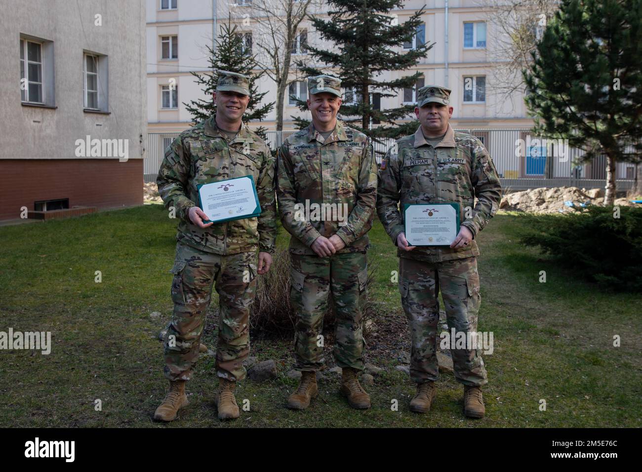 Da sinistra, Sgt. Major Robert S. Wilson, uscente 1st° Divisione Fanteria Forward Sergeant Major, col. Geoffrey A. Norman, vice comandante ufficiale – supporto della 1st° Divisione Fanteria, David M. Pelham, uscente 1st° Divisione Fanteria Forward Operations Sergente maggiore, posa per una foto dopo la cerimonia di premiazione tenutasi a Poznan, Polonia, 7 marzo 2022. La Meritorious Service Medal è assegnata a qualsiasi membro delle forze armate degli Stati Uniti che si distinguono per i risultati eccellenti o per il meritato servizio negli Stati Uniti. Foto Stock