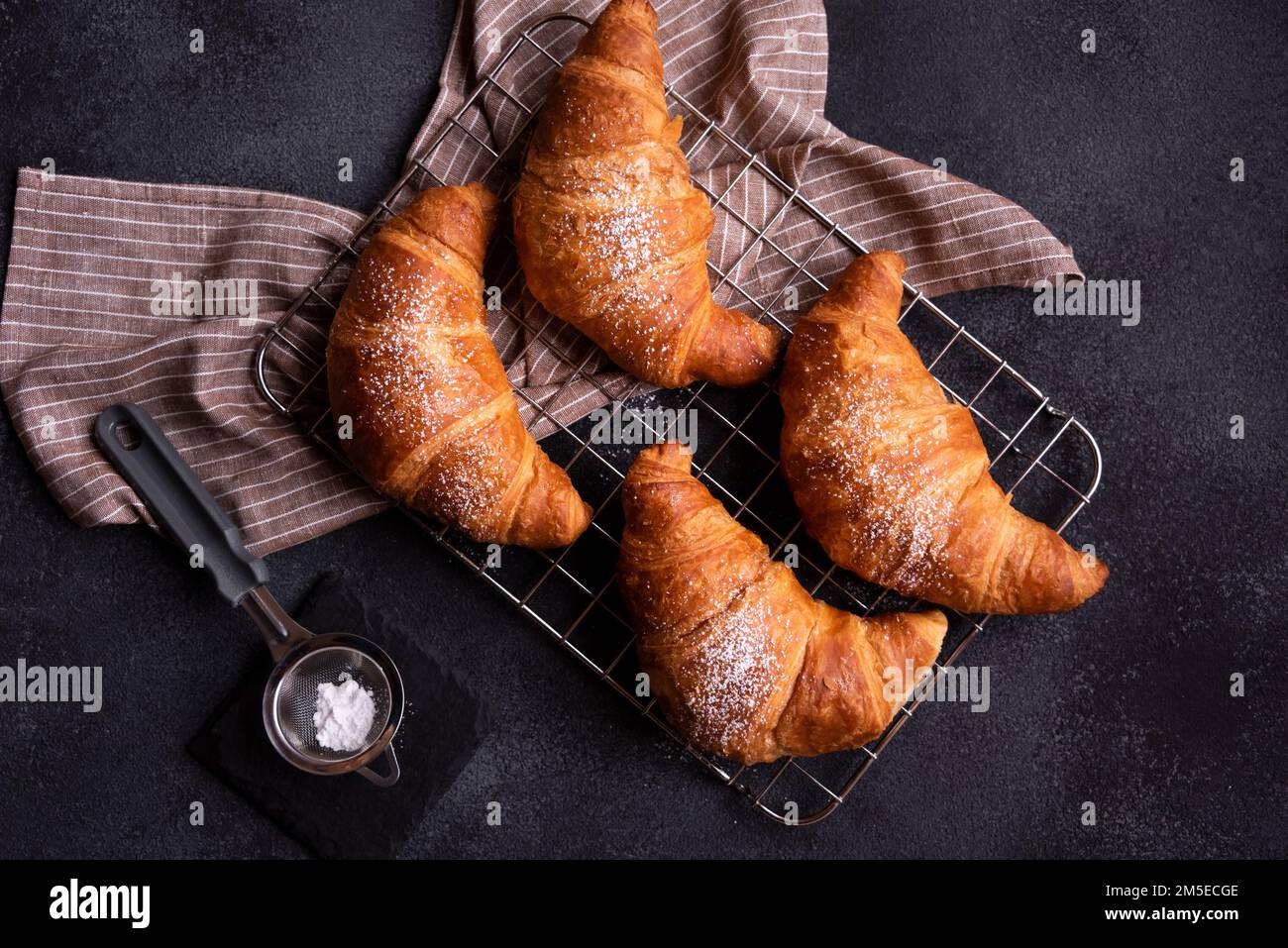 Deliziosi croissant appena sfornati su sfondo scuro Foto Stock
