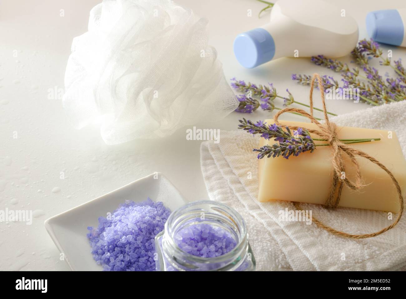 Prodotti da bagno con estratto di lavanda con elementi per l'igiene personale su tavolo bianco. Vista rialzata. Composizione orizzontale. Foto Stock