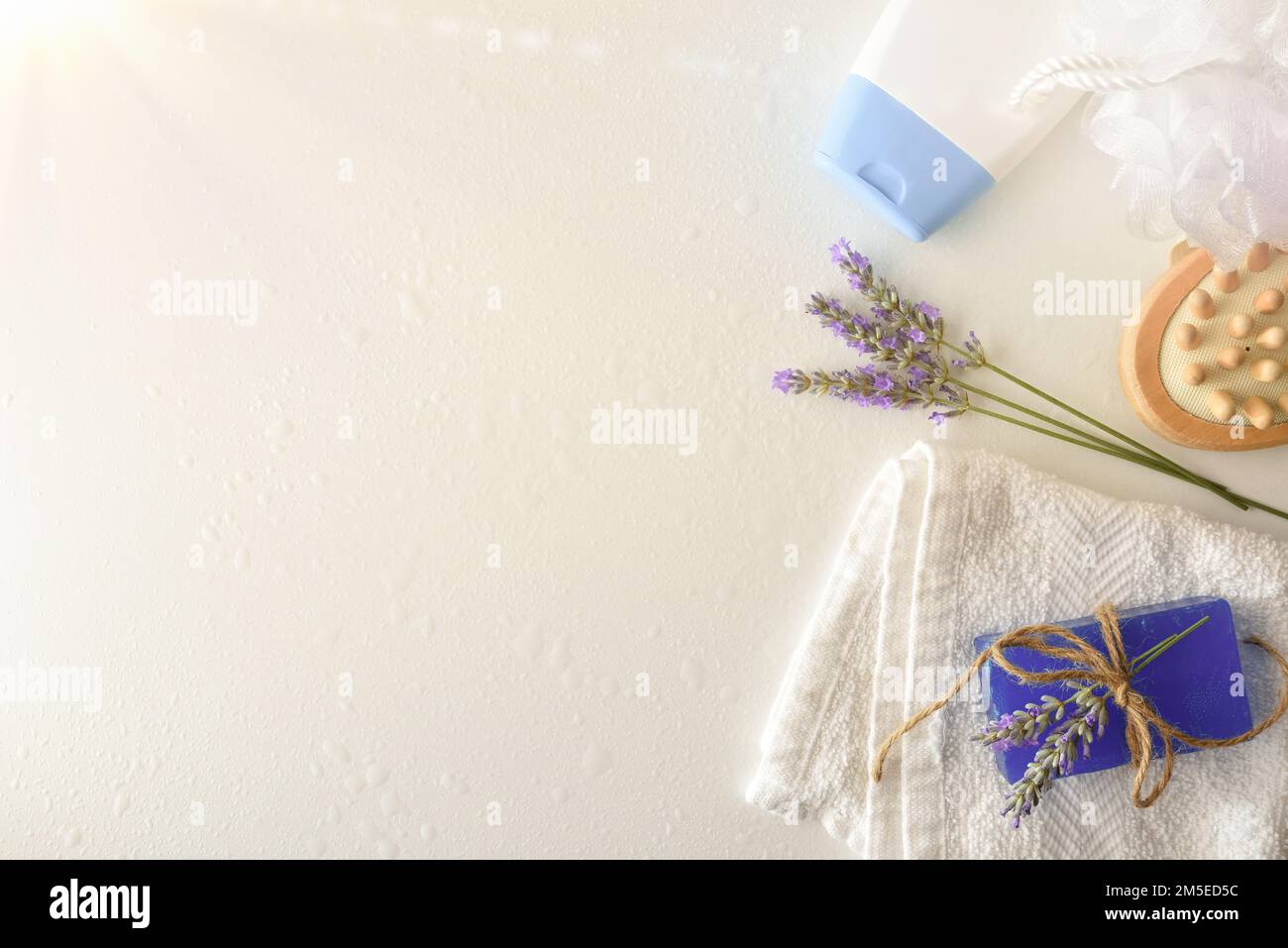 Fondo con prodotti per doccia con estratto di lavanda con elementi per l'igiene personale su tavola bianca. Vista dall'alto. Composizione orizzontale. Foto Stock