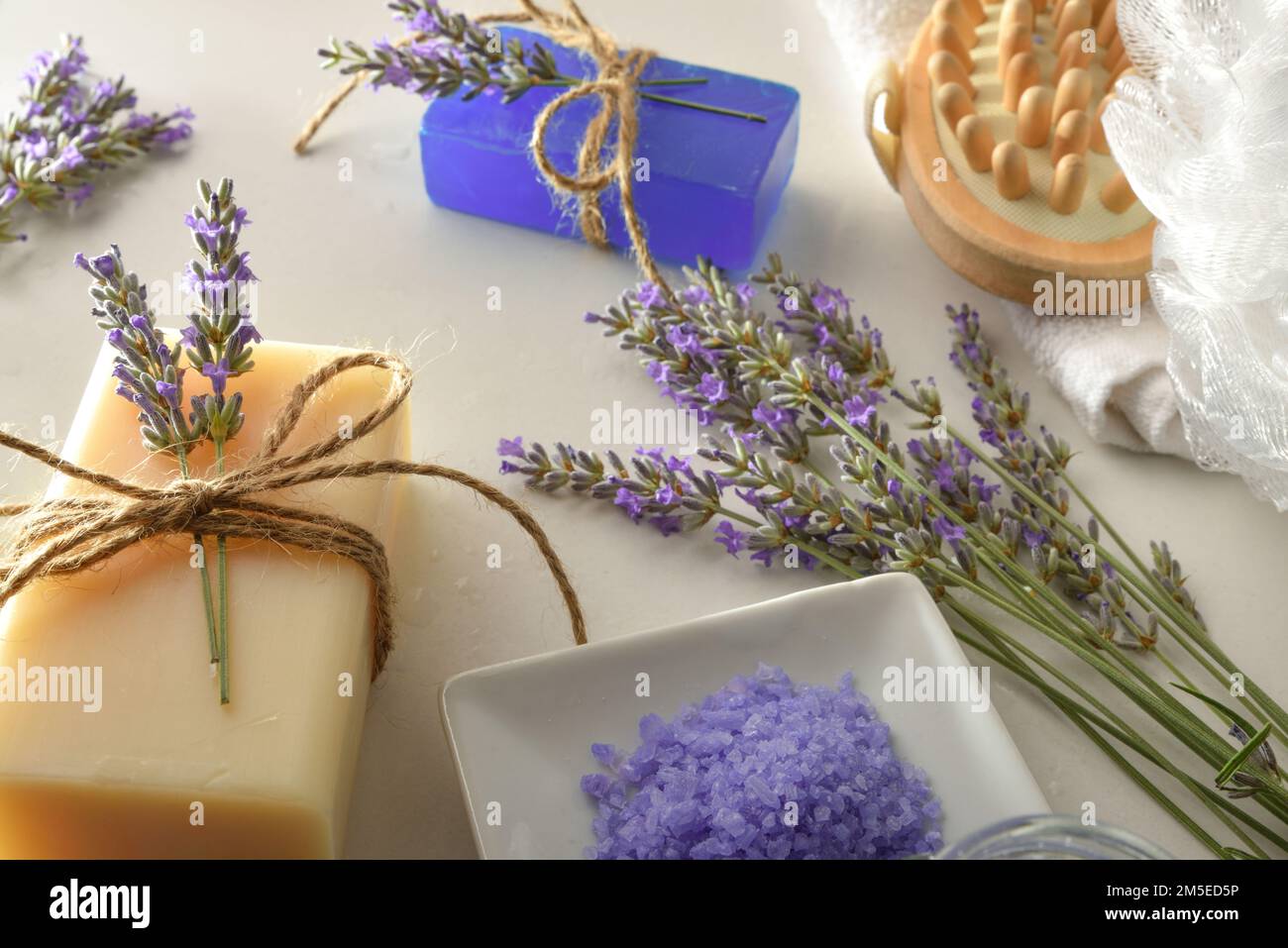 Prodotti per l'igiene personale con essenza naturale di lavanda come sapone per le mani e sali da bagno su tavolo bianco. Vista rialzata. Composizione orizzontale. Foto Stock