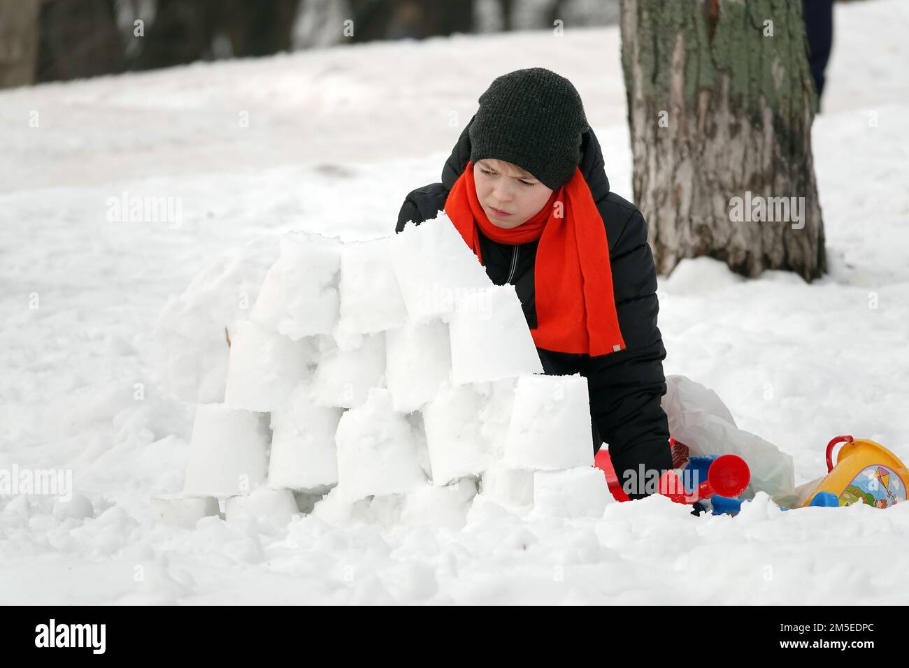 Kiev, Ucraina 21 febbraio 2021: Un ragazzo costruisce una fortezza dalla neve Foto Stock