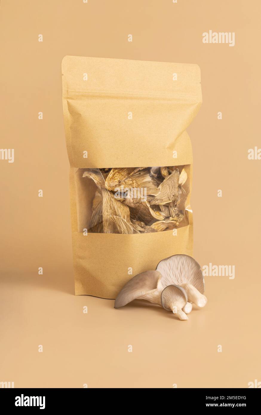 Funghi secchi di ostriche in sacchetto su sfondo beige Foto Stock