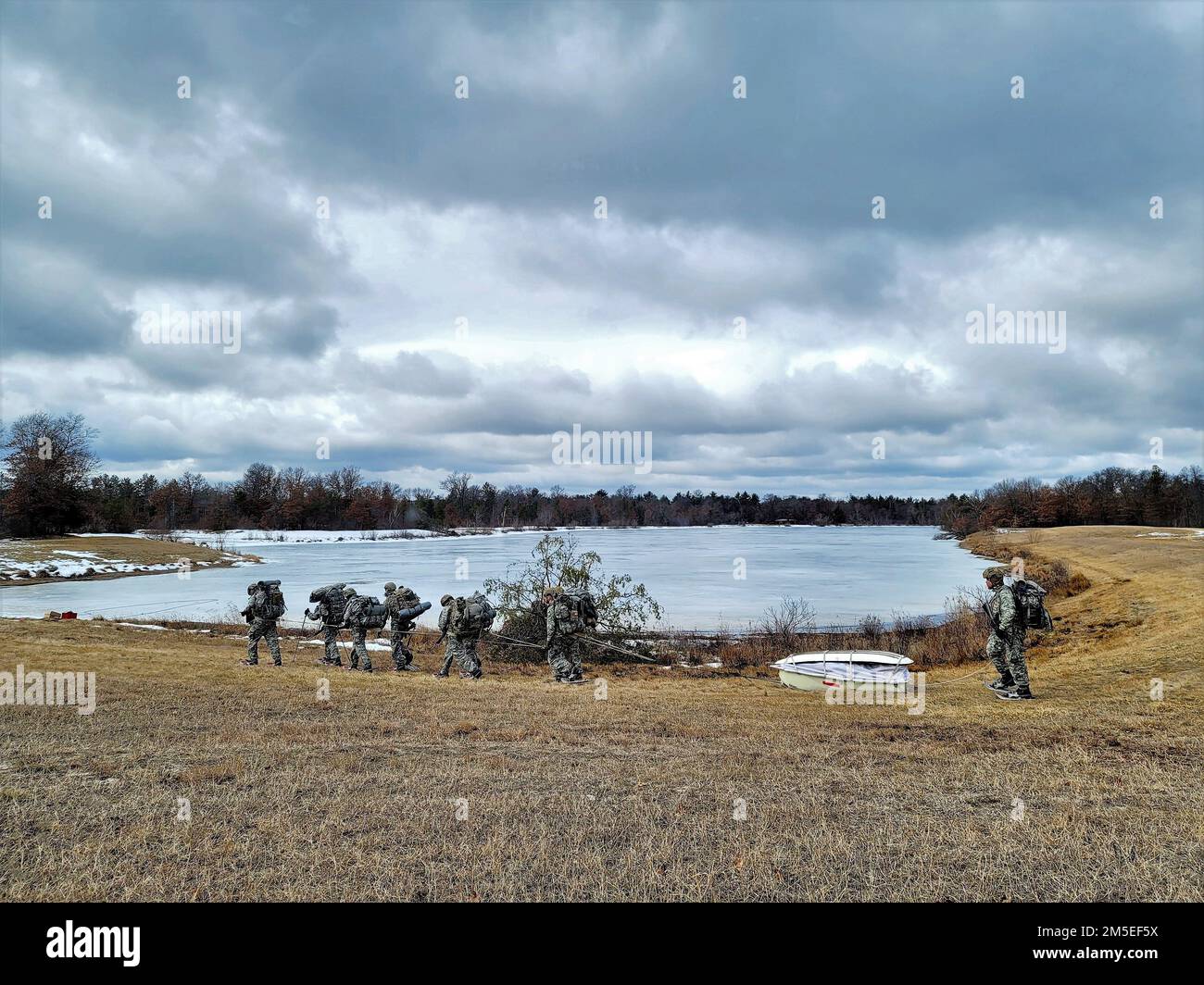 Corso sulle operazioni a basse temperature (CWOC) di Fort McCoy Classe 22-05 gli studenti si esercitano a tirare una slitta ahkio come squadra il 7 marzo 2022, in un'area di formazione a Fort McCoy, Wisconsin. Gli studenti CWOC sono addestrati su una varietà di argomenti legati alle basse temperature, tra cui l'allenamento con le racchette da neve e lo sci, nonché su come utilizzare le slitte ahkio e altri attrezzi. La formazione si concentra anche sull'analisi del terreno e del tempo, sulla gestione del rischio, sull'abbigliamento per climi freddi, sullo sviluppo di posizioni di combattimento invernali sul campo, sul mimetismo e sull'occultamento, e su numerose altre aree importanti da conoscere per sopravvivere e operare in condizioni climatiche fredde Foto Stock