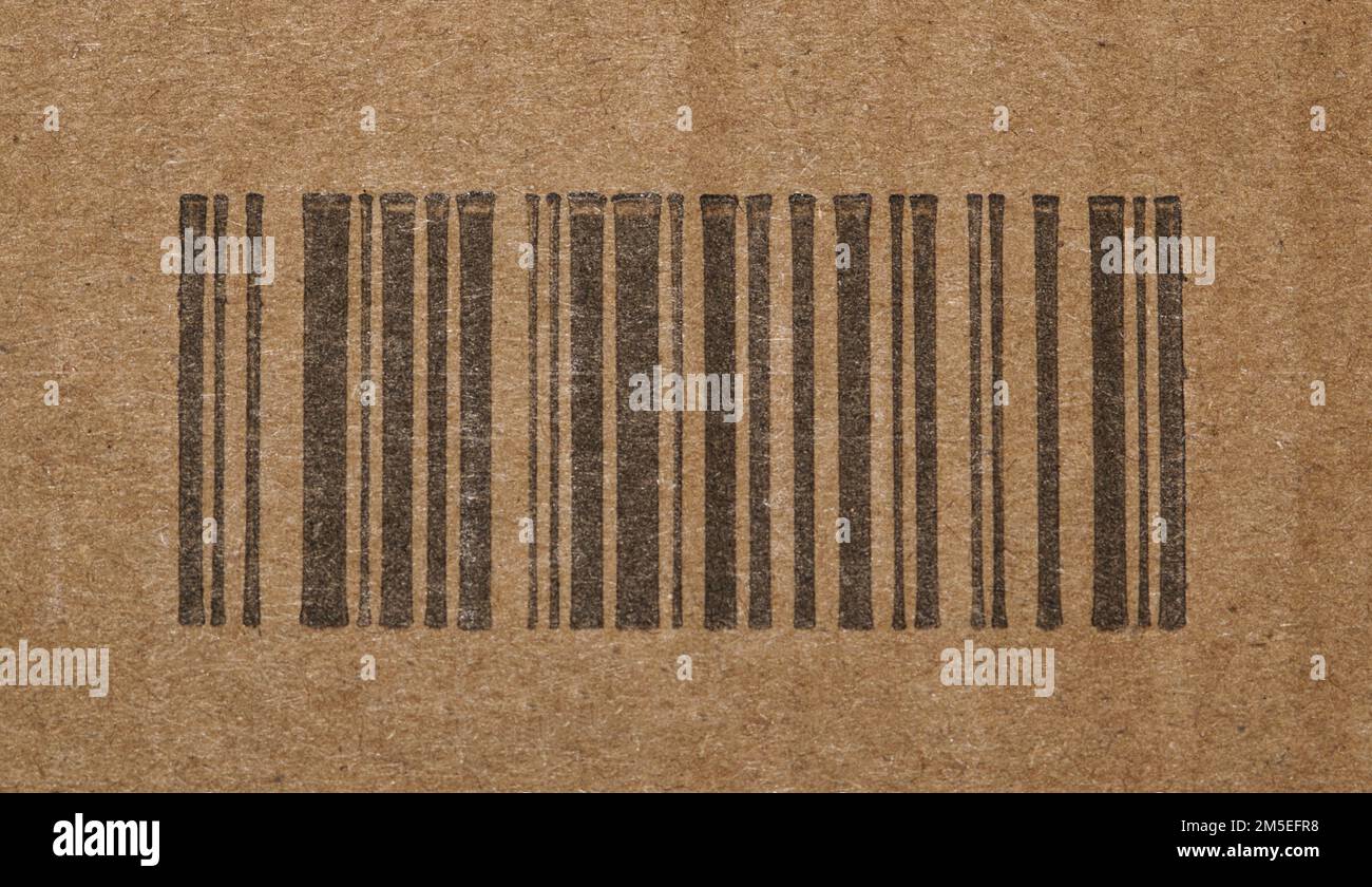 Codice a barre nero generico senza numeri su una scatola di cartone. Primo piano isolato con focalizzazione centrale sulle barre codificate di identificazione. Foto Stock