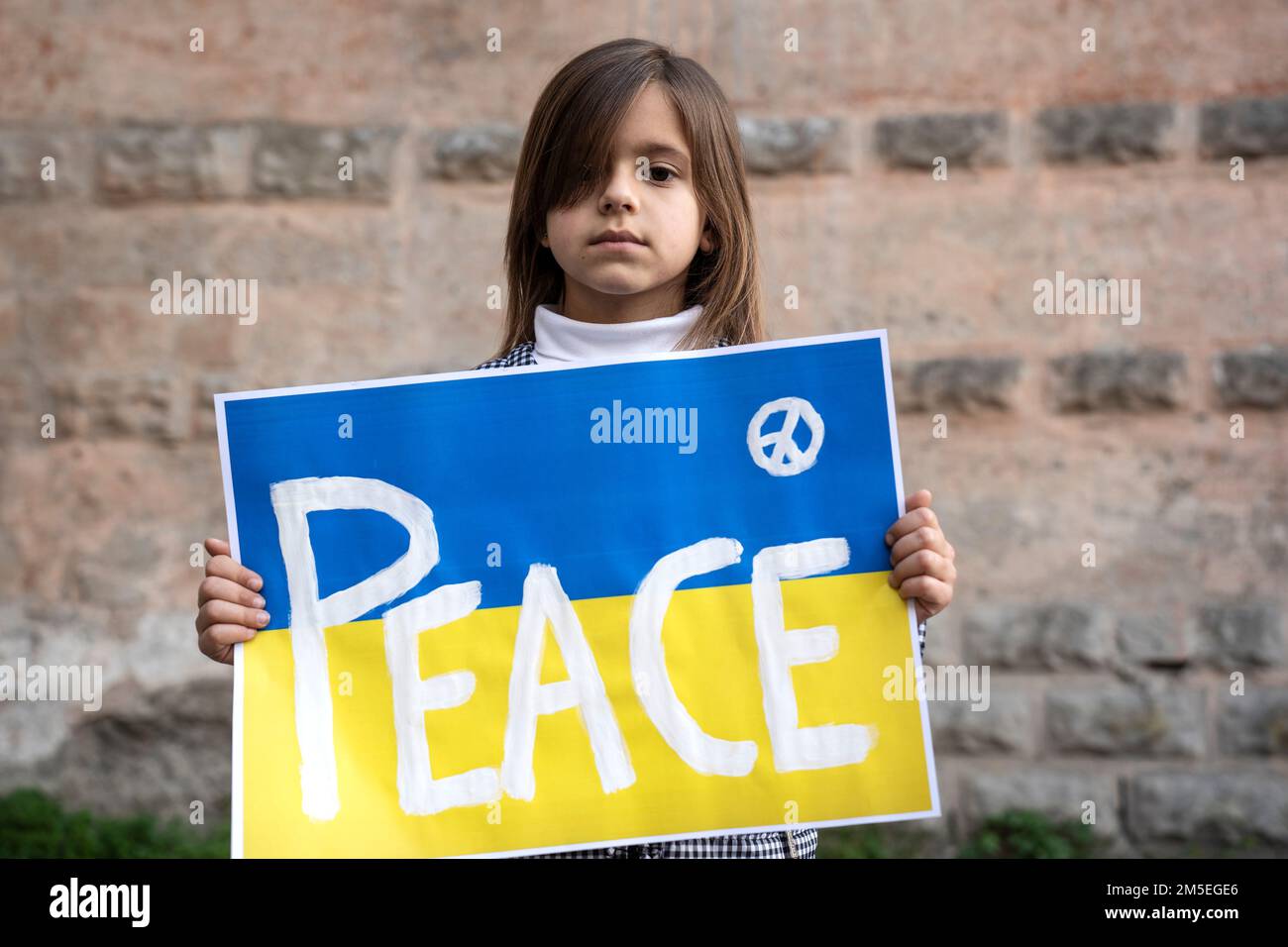 Ritratto della bambina con la bandiera Ucraina e l'iscrizione PACE - solidarietà con i bambini ucraini e le persone che sono currentl Foto Stock