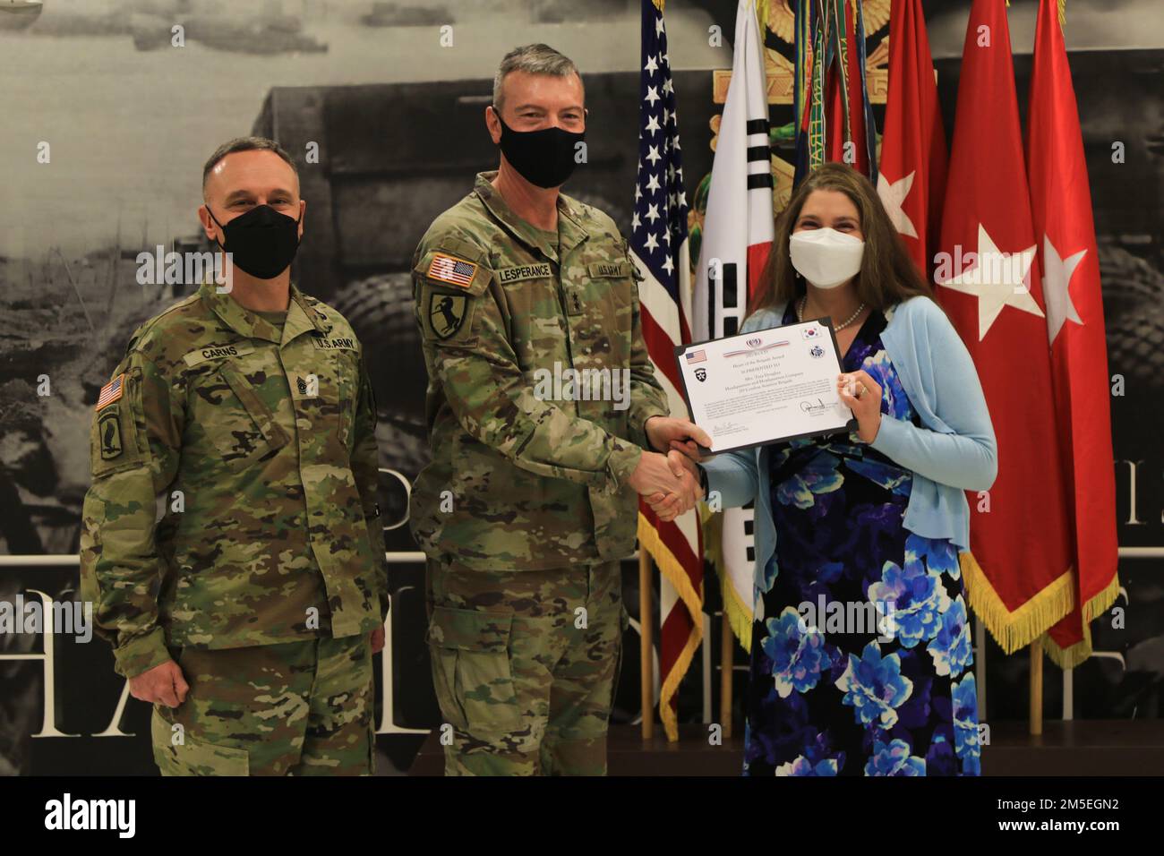 David Lesperance, il comandante generale della 2nd° Divisione di Fanteria/ROK-USA Shawn Carns, consulente senior arruolato del 2ID, presenta il 'cuore della Brigata Award' alla signora Tina Dougher. Dougher ha ricevuto il premio per i suoi sforzi, per un totale di oltre 500 ore di lavoro volontario che assistono i soldati e le loro famiglie all'interno della Brigata dell'Aviazione di combattimento del 2nd. Foto Stock