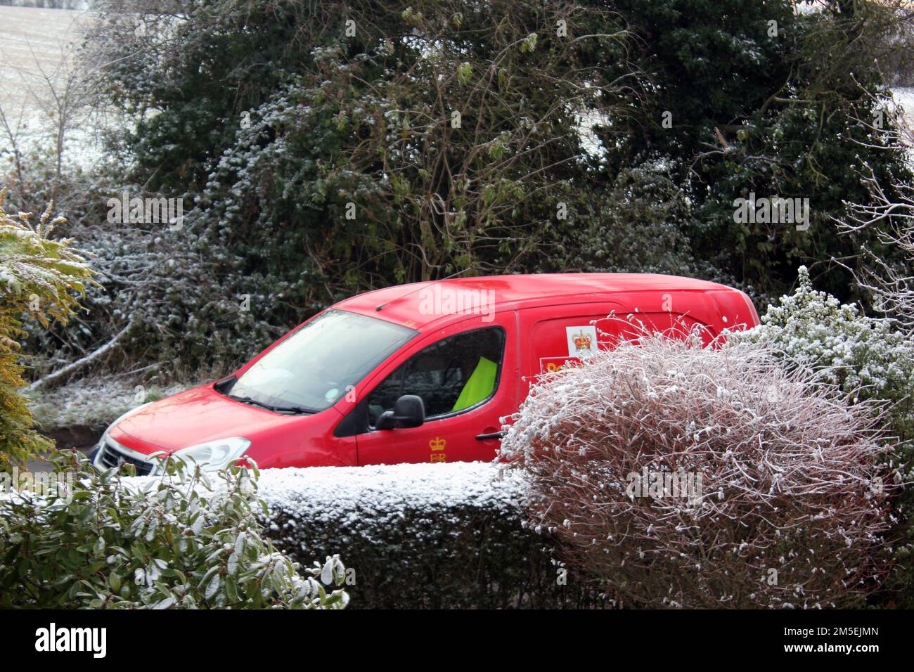 Consegna del Red Royal Mail Van nel villaggio di Oxford durante una dura caduta di neve invernale Foto Stock