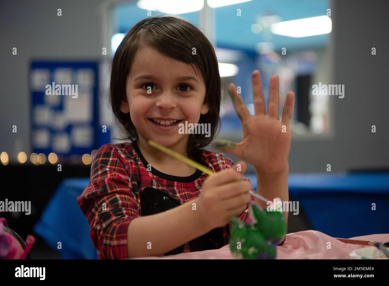 Il bambino di Samantha Fierro, un coordinatore della guardia nazionale dell'esercito dell'Alaska Survivors Survivors, partecipa a un evento di pittura come parte di una celebrazione della Giornata internazionale della donna alla base mista Elmendorf-Richardson, Alaska, 8 marzo 2022. JBER ha ospitato eventi in tutta l'installazione per celebrare le donne e le loro esperienze condivise nei servizi armati. I festeggiamenti includevano una colazione di leadership, una lezione di yoga, un gruppo di leadership e un evento di pittura di ceramica. Foto Stock
