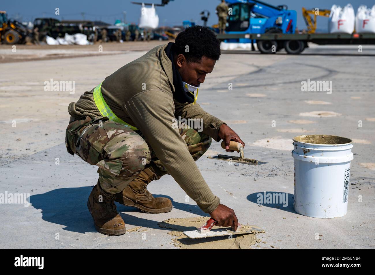 Un ispettore dell'ingegnere civile del 8th, Squadron, Airman, riempie le spall, essenzialmente dove il calcestruzzo si è sfaldato, durante l'addestramento per la riparazione rapida dei danni da campo aereo presso la base aerea di Kunsan, Repubblica di Corea, 9 marzo 2022. La formazione di Airmen da diverse unità nel Wolf Pack garantisce la capacità RADR continua, garantendo così operazioni di volo. Foto Stock