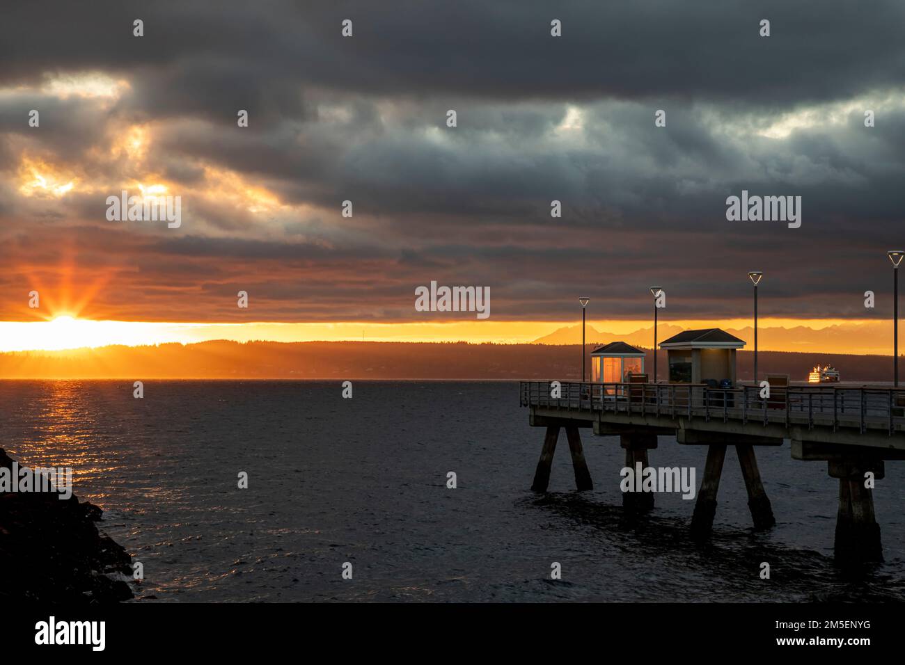 WA22892-00...WASHINGTON - Edmonds Fishing Pier nel Mare di Salish, (Puget Sound), al tramonto con vista del traghetto cross-sound e la montagna olimpica Foto Stock