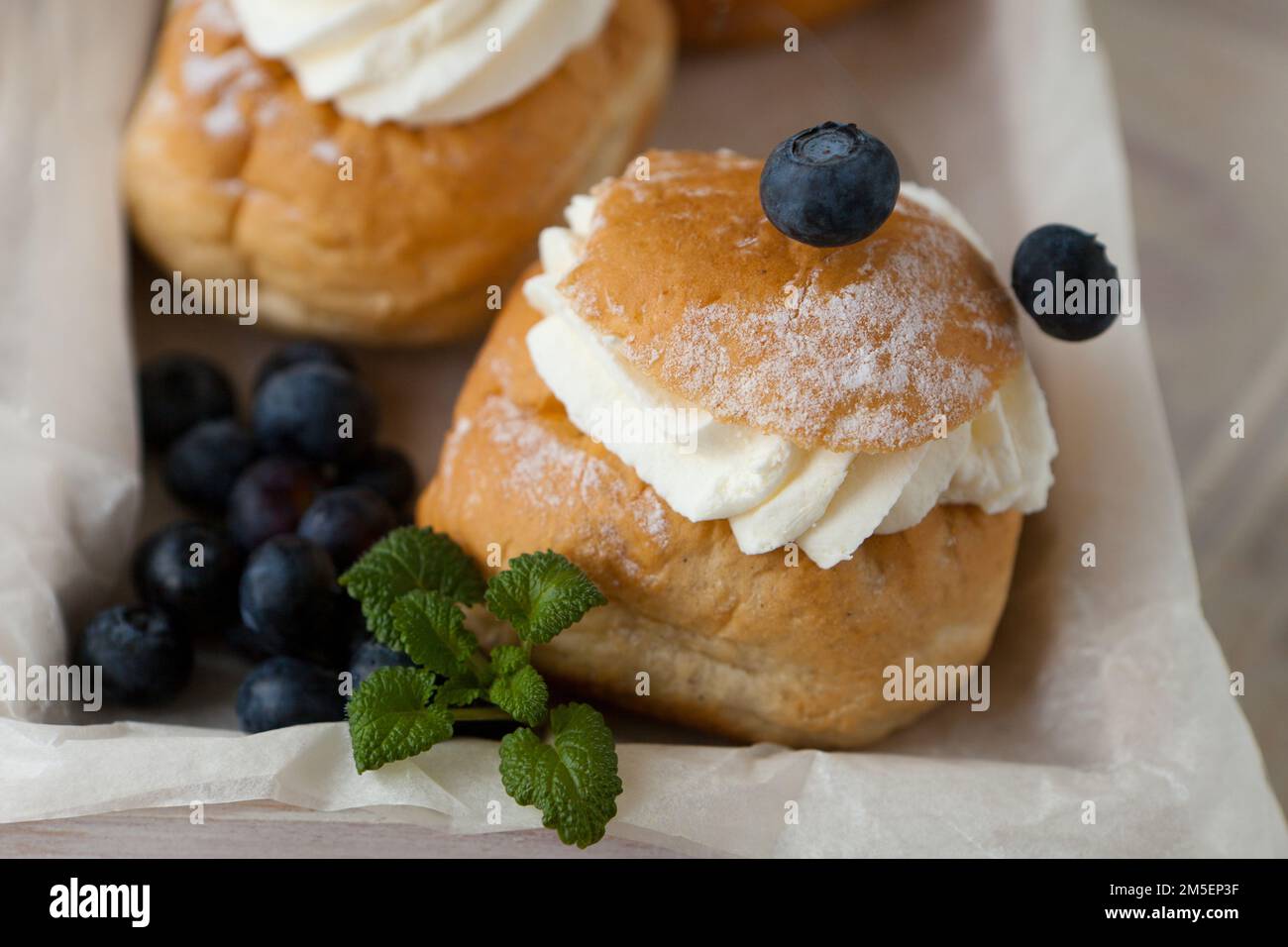 Svedese Semla o Shrove BUN con pane di grano leggero e pasta di mandorle e crema di farcitura montata, menta Foto Stock