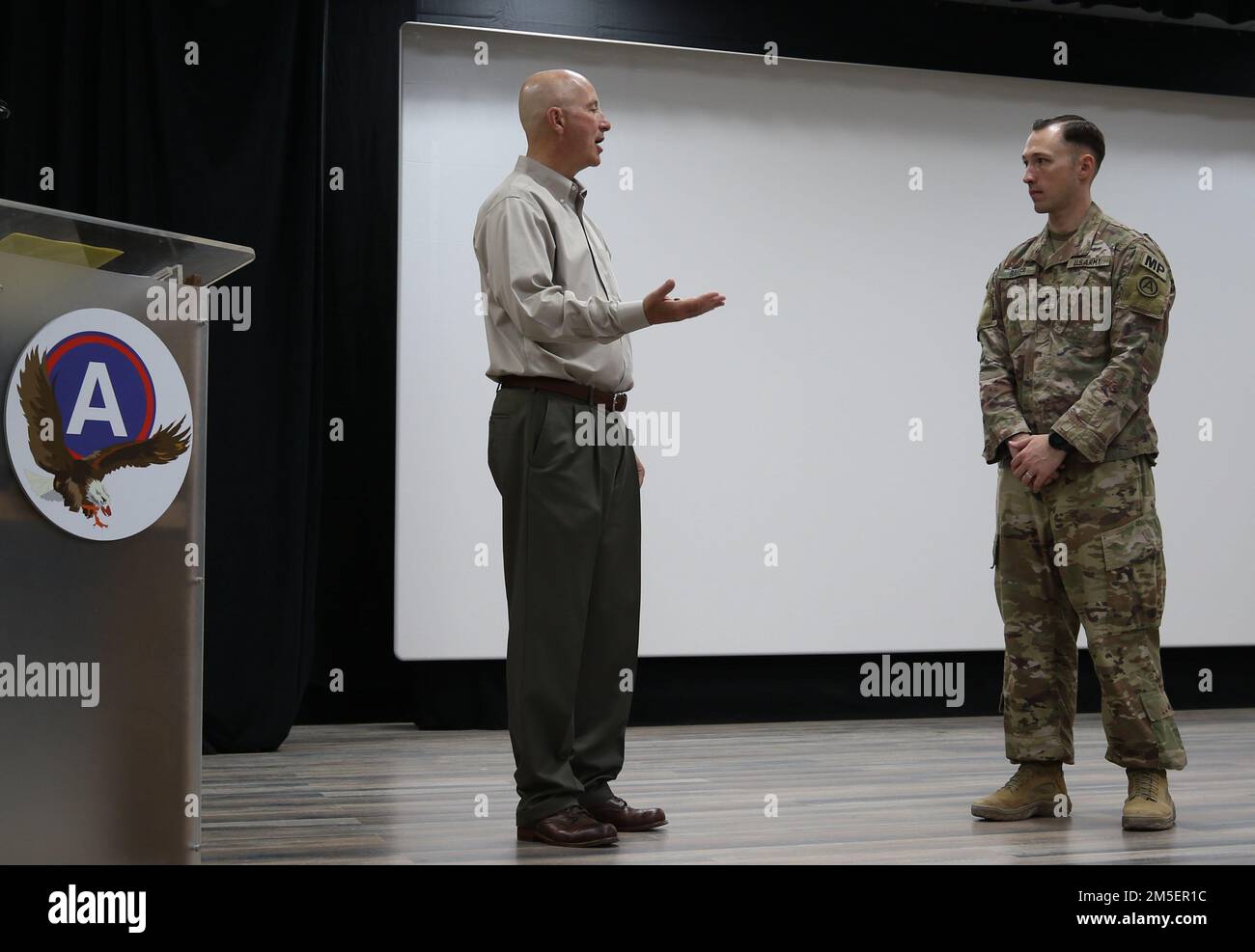 Nebraska Gov. Pete Ricketts si prepara a premiare il capitano Jared L. Baker, comandante uscente, 1057th Società di polizia militare, con una moneta, prima della cerimonia di cambio di comando di Baker a Camp Arifjan, Kuwait, 3 agosto 2022. Baker cede il comando al Capt. Grant J. Hewitt, più tardi quella mattina. Foto Stock