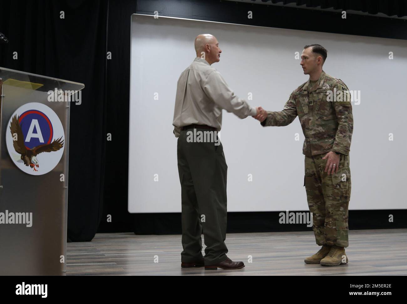 Nebraska Gov. Pete Ricketts presenta una moneta al Capt. Jared L. Baker, comandante uscente, 1057th Società di polizia militare, prima della sua cerimonia di cambio di comando a Camp Arifjan, Kuwait, 3 agosto 2022. Baker cede il comando al Capt. Grant J. Hewitt, più tardi quella mattina. Foto Stock
