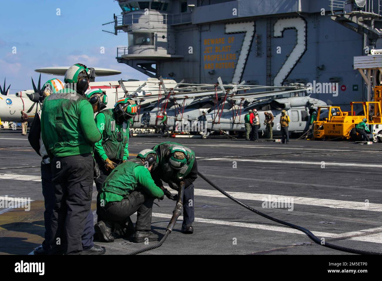 MARE DELLE FILIPPINE (10 marzo 2022) i marinai sostituiscono un filo di arresto sul ponte di volo della portaerei di classe Nimitz USS Abraham Lincoln (CVN 72). Abraham Lincoln Strike Group è in fase di implementazione pianificata nell'area delle operazioni della flotta 7th degli Stati Uniti per migliorare l'interoperabilità attraverso alleanze e partnership e al tempo stesso fungere da forza di risposta pronta a sostegno di una regione indomPacifico libera e aperta. Foto Stock