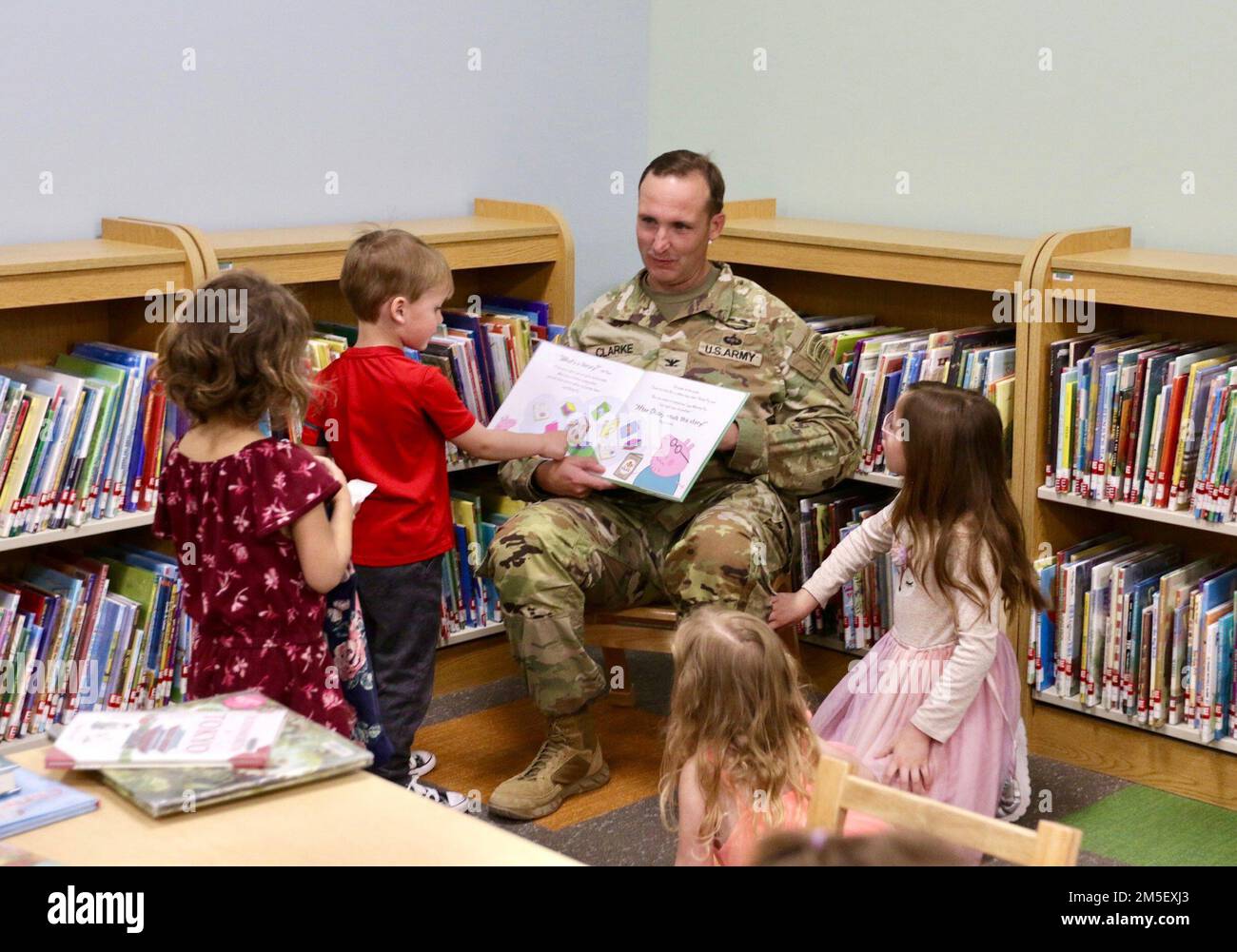 Jason Clarke, comandante della Garrison di Fort Irwin, legge ai bambini nella nuova area per bambini della biblioteca postale. Foto Stock