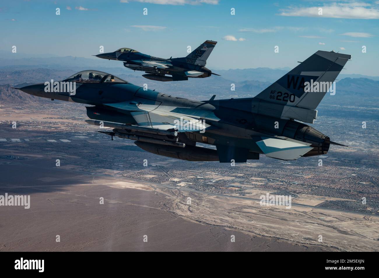 Due F-16 Fighting Falcons assegnati al 64th Aggressor Squadron volano oltre il centro di Las Vegas sulla via del ritorno dopo aver condotto operazioni di combattimento aereo durante Red Flag-Nellis 22-2 9 marzo 2022, presso la base dell'aeronautica militare di Nellis, Nevada. Red Flag-Nellis 22-2 è un esercizio unico che dimostra l'integrazione tattica più all'avanguardia di airpower dagli Stati Uniti e dai suoi principali alleati. Foto Stock