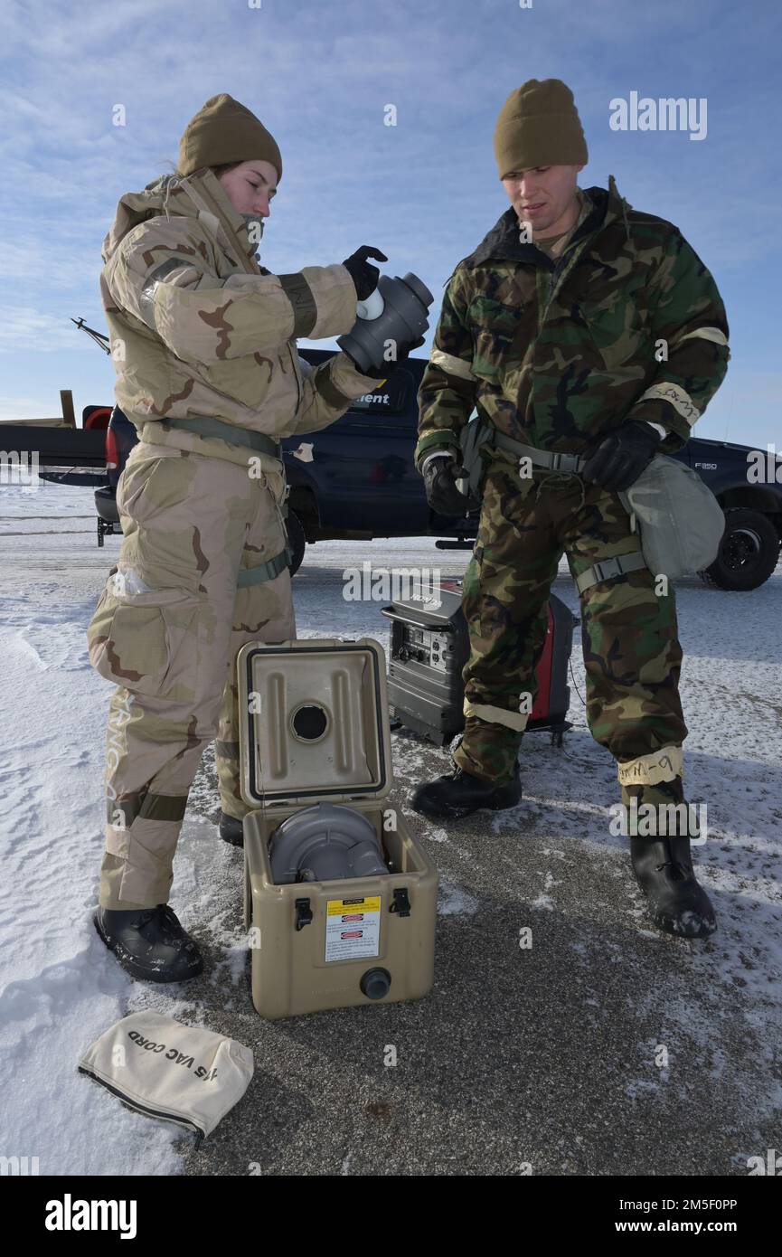 STATI UNITI Membri della direzione di emergenza dell'aeronautica da sinistra a destra Airman Elyssa Johnson, E il personale Sgt. Caleb McNeil, entrambi dell'ingegnere civile Squadron del 114th, Sioux Fall, South Dakota Air National Guard, ha istituito apparecchiature di rilevamento chimico, biologico, radiologico e nucleare (CBRN) durante un esercizio di addestramento presso il North Dakota Air National Guard Regional Training Site, Fargo, North Dakota, 9 marzo 2022. Stanno partecipando a un corso di formazione CBRN per climi freddi per conoscere le sfide presentate durante lo svolgimento di lavori di gestione delle emergenze a temperature estremamente basse. Foto Stock