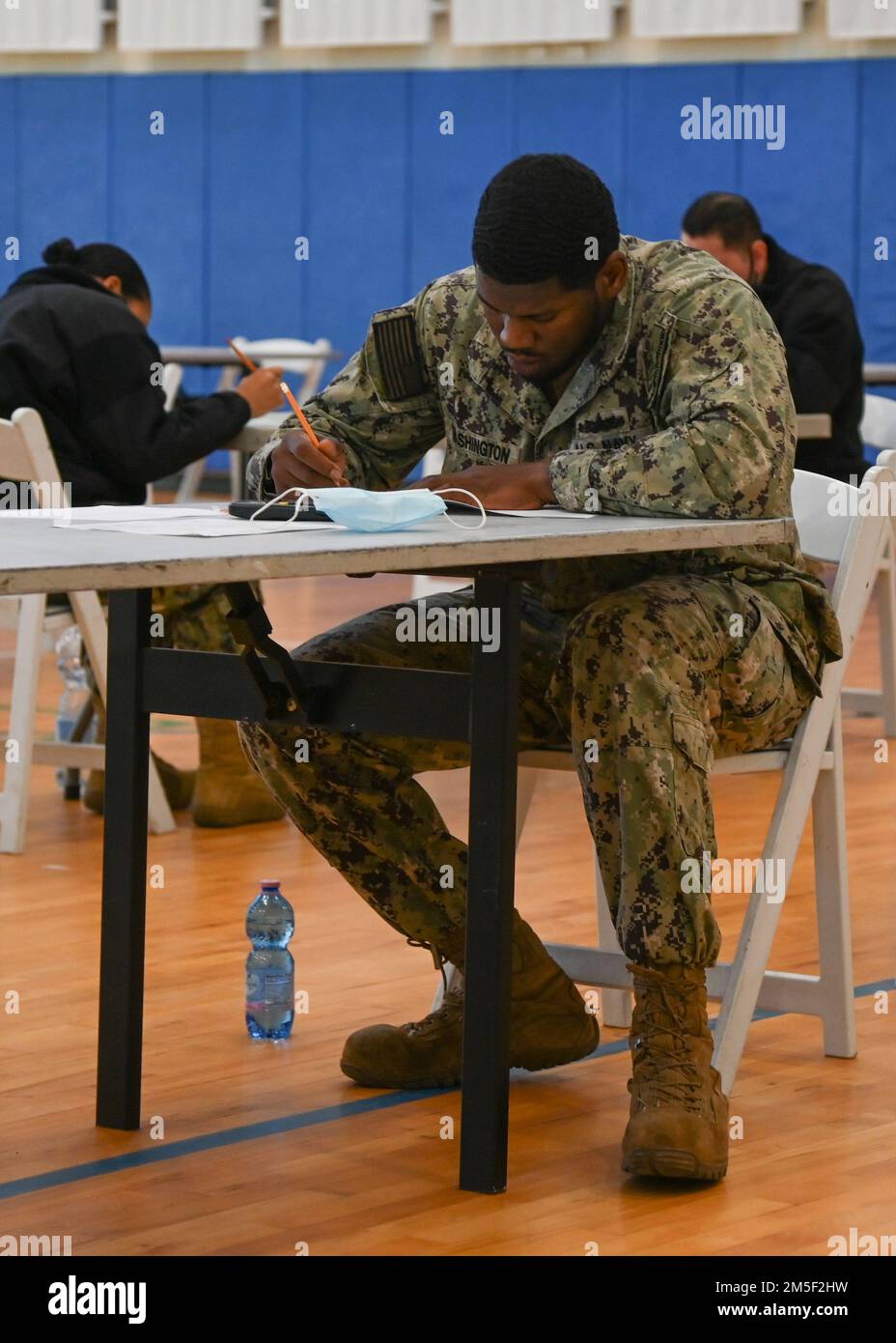 220310-N-GK686-1038 STAZIONE AERONAVALE SIGONELLA, Italia (10 marzo 2022) -- Specialista culinario 2nd Classe Taron Washington prende l'esame di avanzamento e-6 in tutta la Marina sulla Stazione aeronavale Sigonella, 10 marzo 2022. La posizione strategica di NAS Sigonella consente alle forze nazionali degli Stati Uniti, alleate e partner di implementare e rispondere come richiesto per garantire sicurezza e stabilità in Europa, Africa e comando centrale. Foto Stock