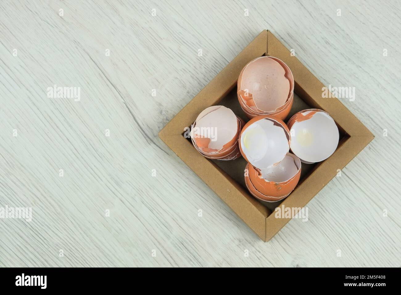 Pila di gusci d'uovo rotti spaccati sulla piastra di cartone. Rifiuti organici per compost. Vista dall'alto. Spazio di copia. Foto Stock