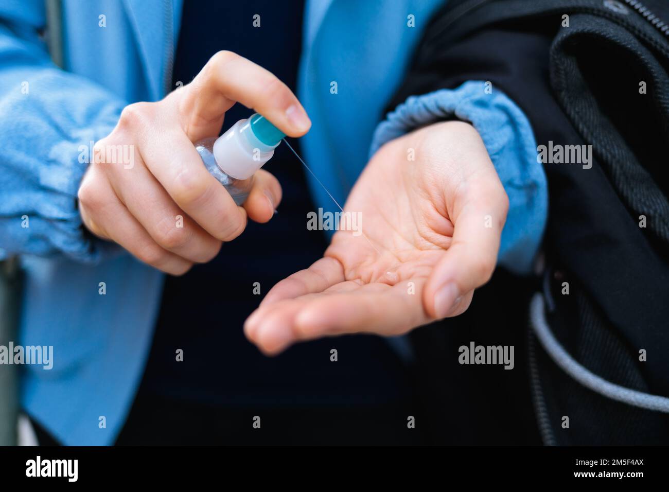 Un primo piano delle mani di una donna utilizzando un disinfettante per le mani - il concetto di una pandemia Foto Stock