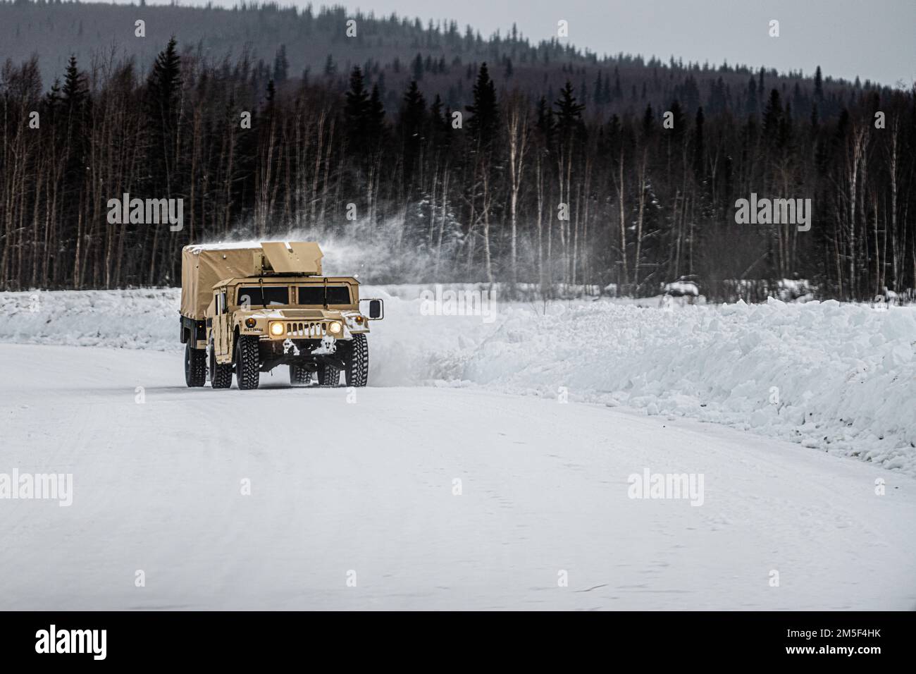 Un Humvee, assegnato a 265th Air Defense Artillery Regiment, Florida Army National Guard, che trasporta istruttori di volo in cattività (CFT) si avvicina a un'area di allestimento del sistema di difesa aerea Avenger durante l'esercitazione ARCTIC EDGE 2022 presso la base aeronautica di Eielson, Alaska, 10 marzo 2022. Avengers è stato caricato con CFT per fornire un ambiente di formazione realistico durante il AE22, un biennale degli Stati Uniti Esercizio di difesa della patria del comando del Nord. Foto Stock