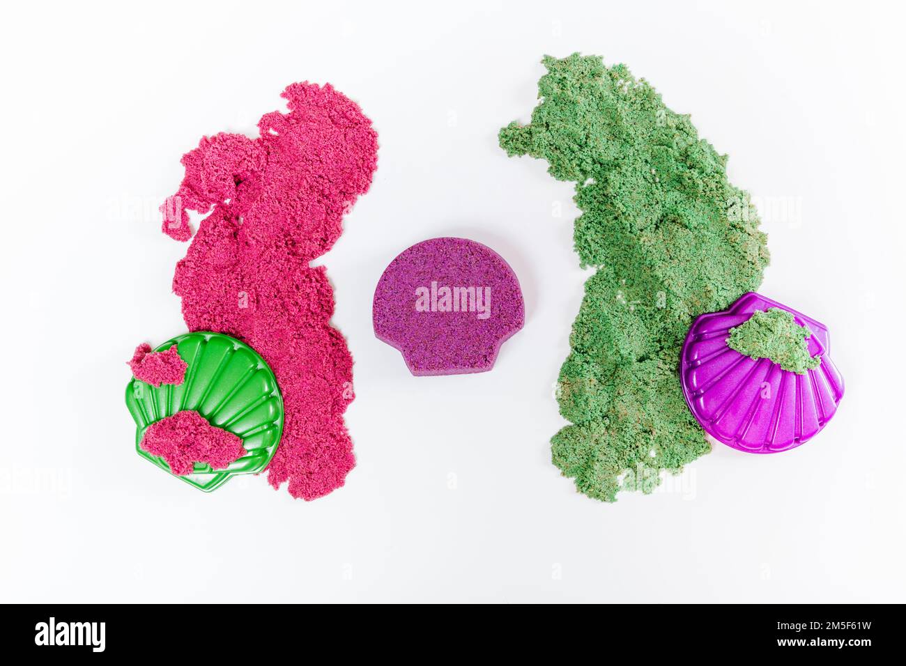 Sabbia cinetica colorata, stampi in plastica per sabbia. Il bambino scolpisce e gioca con la sabbia. Giacitura piatta. Sfondo bianco Foto Stock