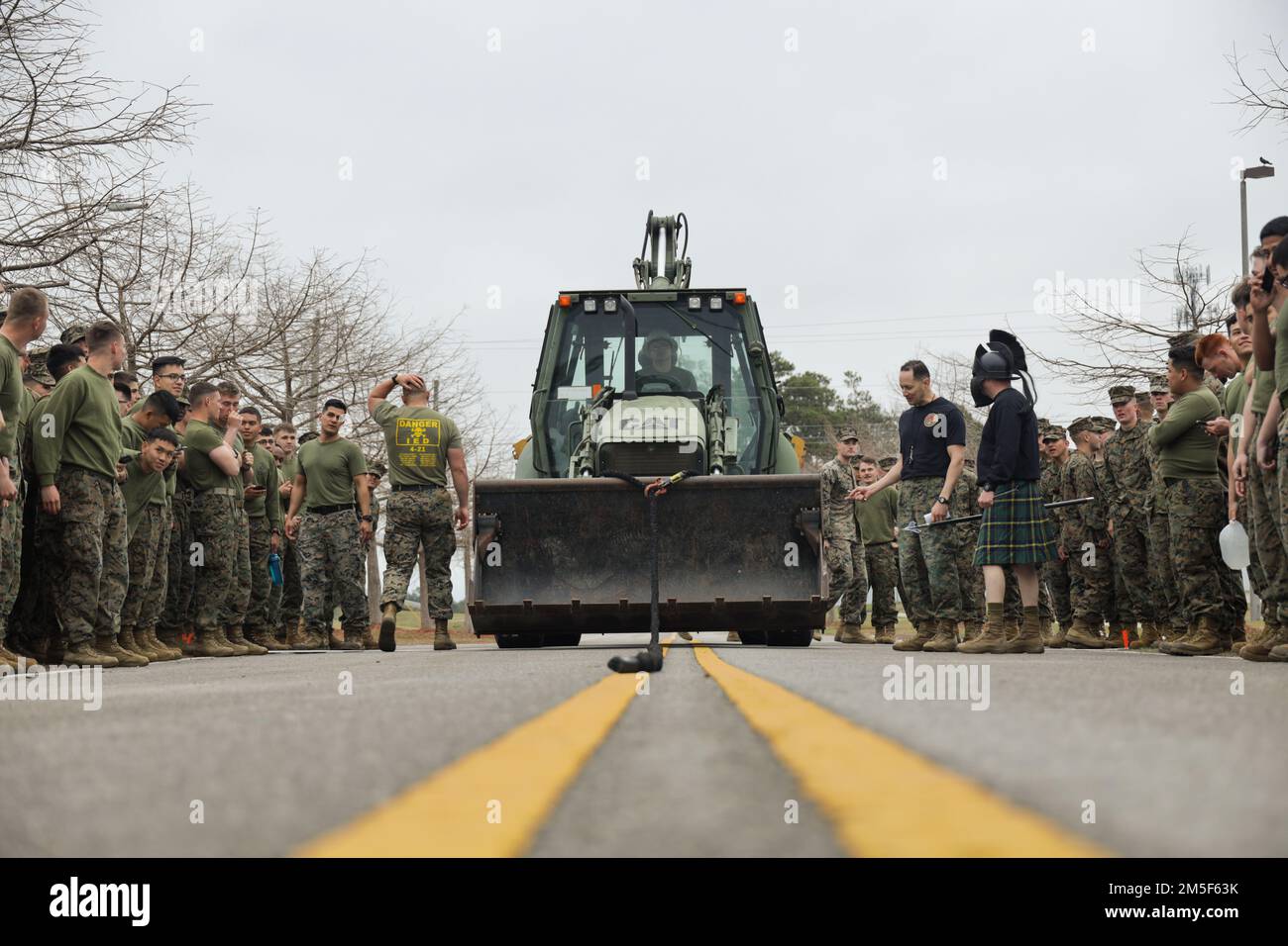 STATI UNITI Marines con la 2D Marine Division si preparano a partecipare a un'operazione di trazione del retroescavatore durante la Marine Corps Engineering School Saint Patrick's Field Meet a Camp Lejeune, North Carolina, 10 marzo 2022. La riunione annuale sul campo invita gli ingegneri di varie unità a riunirsi e a competere in una serie di sfide correlate agli ingegneri. Foto Stock
