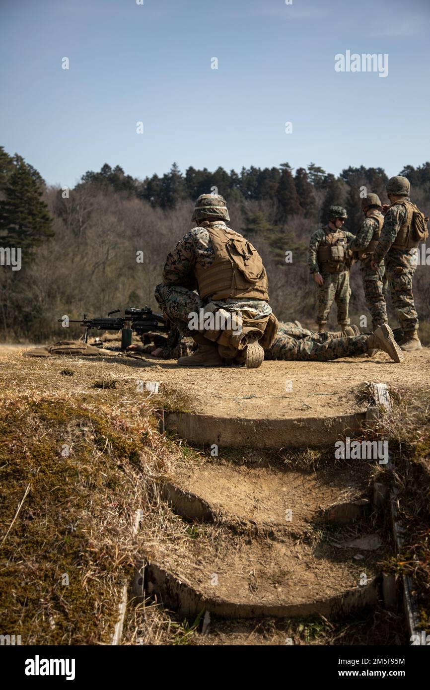 STATI UNITI Marine Corps Sgt. Troy Williams, un operatore di rifornimento di semirimorchio con Marine Wing Support Squadron (MWSS) 171, aiuta Marines a sparare una mitragliatrice leggera M249 al Japan Ground Self-Defense Force Camp Nihonbara, Giappone, 10 marzo 2022. Marines e marinai con MWSS-171 e Marine Air Control Squadron 4 hanno partecipato all'esercizio Tanuki Wrath 2022 per migliorare le loro abilità nella creazione di una base operativa in avanti, la creazione di un punto di armamento e rifornimento in avanti, e la conduzione di addestramento di armi da fuoco vivo. Foto Stock