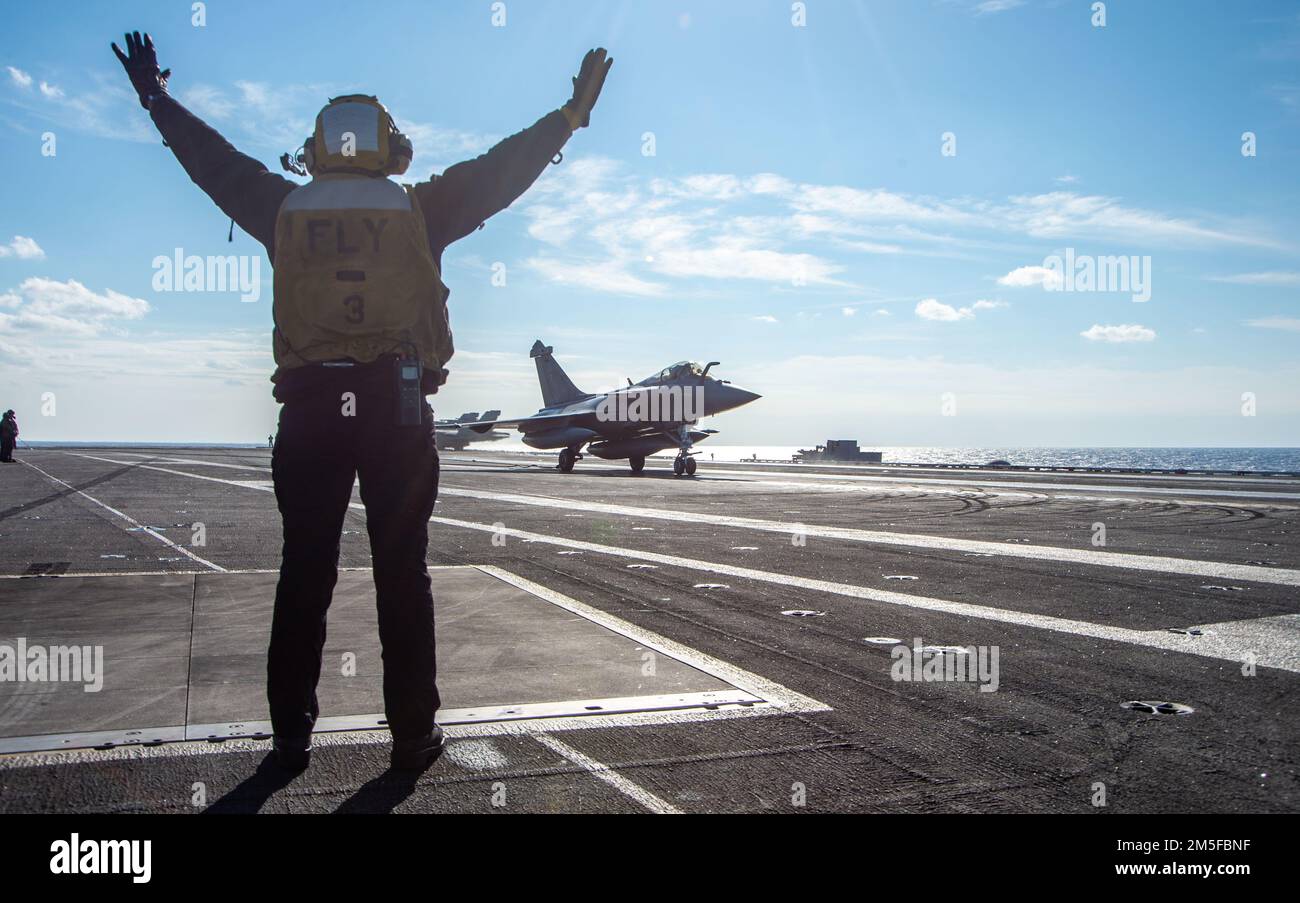 220311-N-ZE328-1409 IONIAN SEA (11 marzo 2022) Aviation Boatswain's Mate (Handling) 3rd Class Kallista Zimmerman, di Cedar City, Utah, dirige il pilota di un francese Rafale F-3R sul ponte di volo della portaerei di classe Nimitz USS Harry S. Truman (CVN 75), 11 marzo 2022. Il gruppo Harry S. Truman Carrier Strike Group è in fase di implementazione pianificata negli Stati Uniti Sesta area di attività Fleet a sostegno degli interessi degli Stati Uniti, alleati e partner in Europa e Africa. Foto Stock